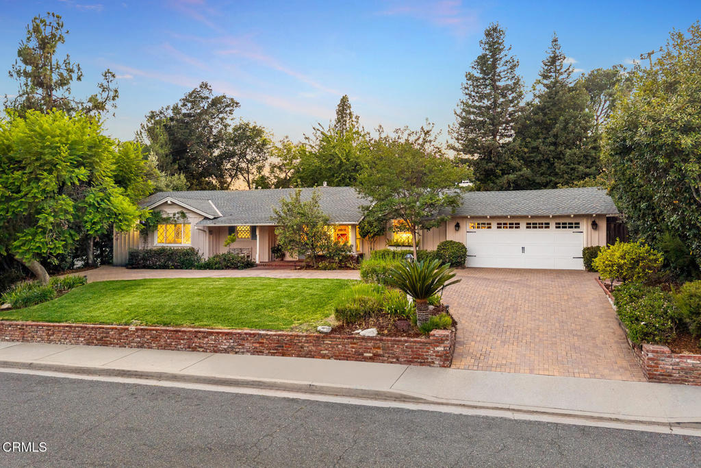 Classic charmer in the heart of La Canada Flintridge! Perched above the street in the coveted PCY area of town, this home welcomes you with a horseshoe drive, attached garage and charming curb appeal. A covered front porch welcomes you into the home while offering a place for sitting with San Gabriel Mountain views. Inside an entry with coat closet opens to the living spaces. The kitchen rests at the front of the home and is complete with a breakfast nook elevated by a built-in bench and corner windows, built-in desk space, large pantry and garage access. Custom wood cabinets surround and granite counters span the space giving plenty of room for use. Stainless-steel appliances including a Sub-Zero refrigerator, 5-burner Thermador stovetop, Thermador double oven and dishwasher. With access from the kitchen and entry, a dining room blends into a family room with large bench seat picture window and French doors, filling the room with ambient light. A brick fireplace rests in a corner, flanked by built-in book shelves and entertainment nook. Through the French doors, a covered porch offers a perfect place for outdoor lounging. Additionally accessed from the entry, a formal living room with warming fireplace rests to the side of the family room, giving additional space for entertaining. The spacious floor plan includes four bedrooms, three bathrooms and a laundry room that are conveniently located down a hall from the entry. A full guest bathroom serves one bedroom while two bedrooms share a bathroom between. A spacious primary suite rests at the back of the home with full bath, double sinks, large closet, vanity nook and additional access to the back porch. A lush garden fills the yard with St. Augustine lawn, flowing planters and multiple mature fruit trees including avocado, persimmon, pear, and apple. An additional patio rest to the side off the family room, perfect for barbecuing and dining. Enjoy living with easy access to town while being just around the corner to beloved Paradise Canyon.