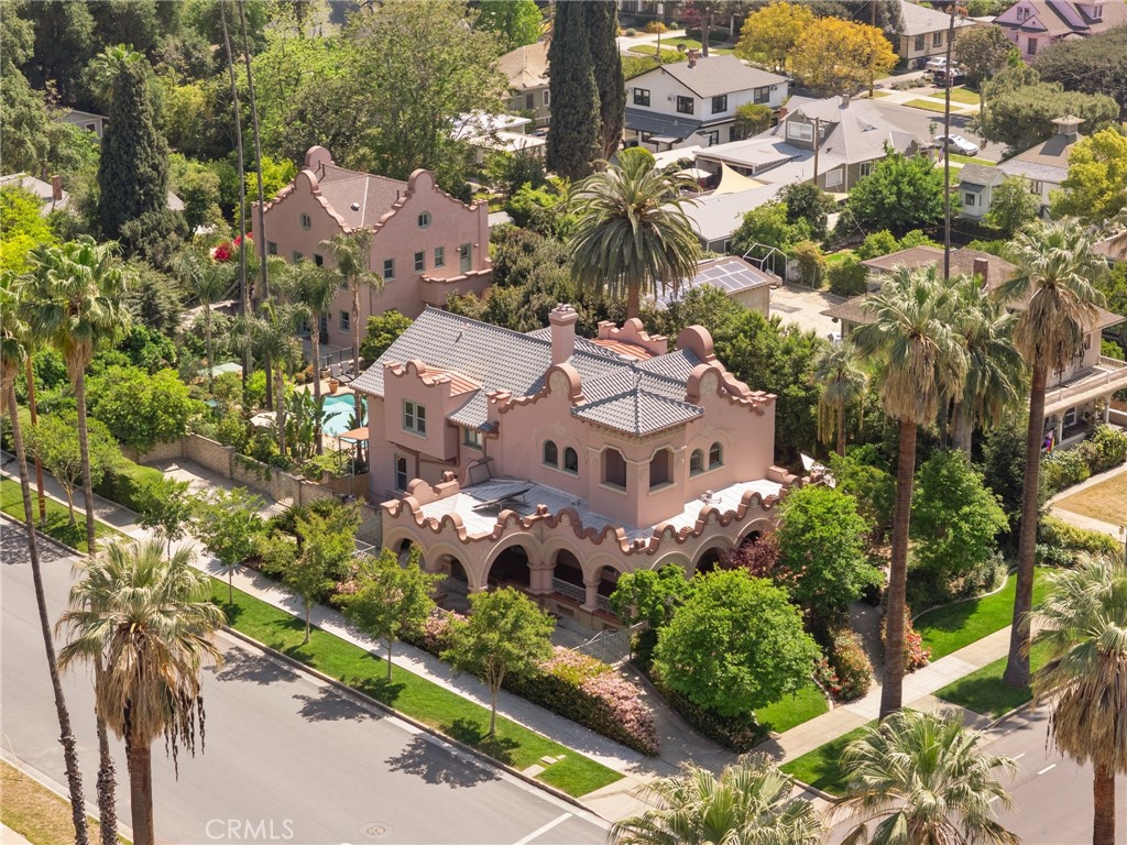 Commanding attention from its prime location at W Olive Avenue and Alvarado Street on a sprawling, meticulously landscaped half-acre, lies William F Holt's heritage award winning Mission Revival masterpiece : a stately 4,371 sq ft main residence AND fully converted 2,400 sq ft carriage house with separate gated drive offering additional upstairs and downstairs living quarters! William poured his soul into this architectural masterpiece creating a treasure of love and legacy. A classic wrap-around porch framed by flourishing gardens and mature trees beckons you to relax. Step inside to sky-high ceilings, original architraves, and a charming reading nook. The parlor, bathed in natural light through expansive windows, features gleaming original hardwood floors and elegant pocket doors. The grand foyer impresses with a cozy wood-burning fireplace, 12-foot ceilings throughout, and handcrafted decorative detailing that whispers of 1903 craftsmanship. Entertain with elegance in the formal dining room, where a magnificent chandelier sets the tone, flanked by original built-in china cabinets and period-appropriate accents that elevate every gathering. The kitchen is a culinary delight with sweeping views of the backyard and koi pond, a walk-in pantry, and an adjoining laundry area with linen storage and backyard access. The main level also features a spacious bedroom with patio access and a full bathroom. Upstairs, four bedrooms unfold. Highlights include multiple private patios once cherished by a local author for its tranquil views, built-in features, and original sinks in select rooms. The carriage house behind the main home offers finished upper and lower level separate living spaces. A private courtyard oasis with sparkling pool and spa is surrounded with lush landscape where over 100 lovingly maintained fruit trees provide a canopy of flavor and fragrance. Enjoy a koi pond bursting with vibrant aquatic life. An original porte cochère, now serves as stylish covered parking with added space for RV or boat storage. Below the estate boasts a rare and whimsical feature: a single-lane bowling alley complete with original pins—an unforgettable tribute to the home’s playful past. Ideally situated near the Redlands Bowl and downtown Redlands charming shops and restaurants—it’s a once-in-a-generation opportunity to own a living piece of Redlands history. This legacy estate invites you to write the next chapter in its enduring story.