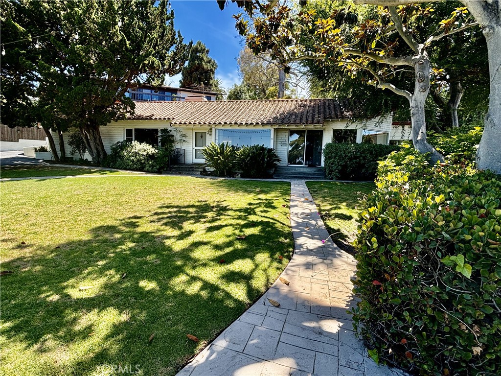 Beautiful one-level home with expansive city, mountain, and Queen's Necklace Ocean views situated on a large lot at the bottom of a private driveway. Newly upgraded fixtures and lighting, hardwood floors, spacious kitchen, two fireplaces, and a wet bar. This home has the feel of a hillside retreat, with ample space and light throughout, and lush greenery surrounding the exterior. The detached two-car garage features a large downstairs bonus room that can be used as a gym, office, or guest room. Walking distance to best elementary school. This is a place you will look forward to coming home to.