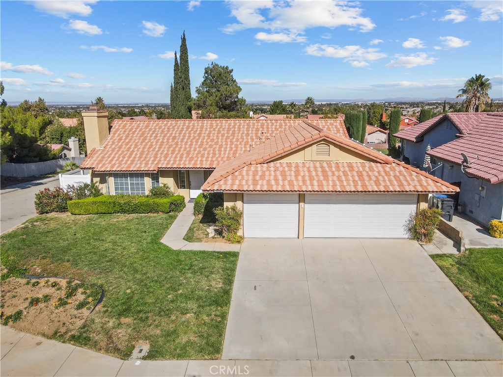 This single-story West Palmdale corner home is in the desirable Rancho Vista community! This 4 bedroom, 2 bathroom home is 1,666 SF, built in 1995 and on a 7,103 Lot. As you enter you’ll notice all the natural light and the beautiful laminate flooring, spacious living room with fireplace and dining room with ceiling fan. The adjacent kitchen features granite countertops, newer appliances, garden window that looks out to the backyard, breakfast counter that opens to the family room with sliding door to the backyard patio. The primary bedroom and bathroom offers 2 closets, dual sinks and a sliding door to the backyard. All four bedrooms are carpeted. There is a hall bathroom with a shower in the bathtub.There is an indoor laundry room leading to the 3-car garage with good storage. The spacious backyard features a vinyl fence. Additional features: Refrigerator (2023), dishwasher (2024), stove (2024) and microwave (2024), HVAC (2022), water heater (2023) and vinyl fencing (2021). Close to Marie Kerr Park, Rancho Vista golf course, Amphitheatre, Antelope Valley Mall, Highland High School, walking trails, shopping, restaurants, 14 freeway and more!