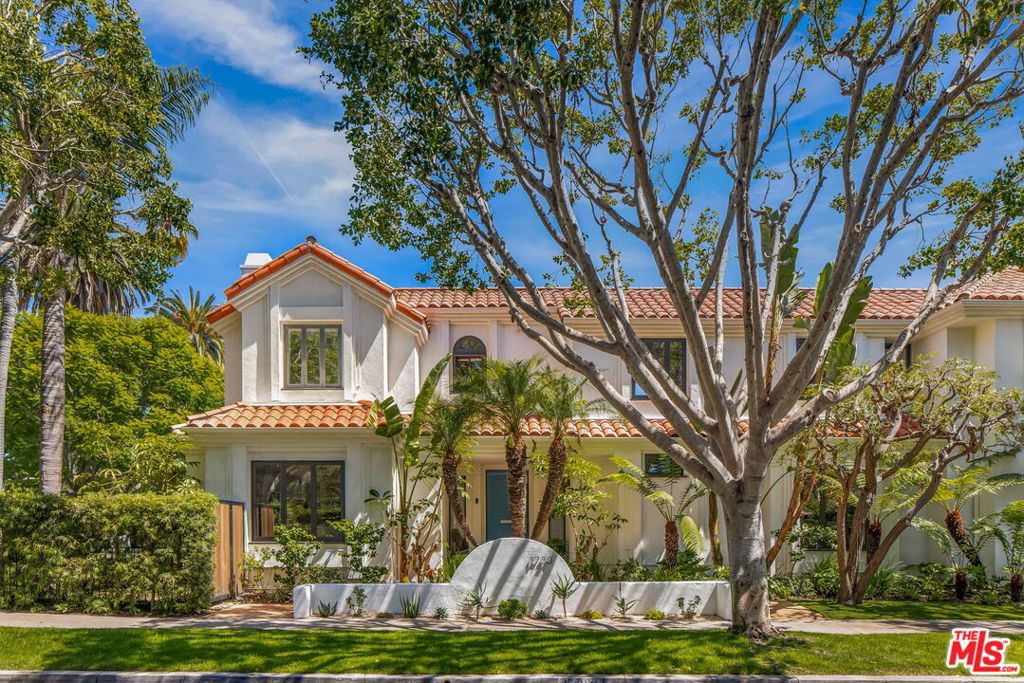 This Spanish residence on one of Santa Monica's most iconic streets has been thoughtfully reimagined for modern living, while preserving the scale, symmetry, and natural flow that define its architectural roots. Located on a coveted corner lot along Georgina Avenue, the home opens to sun-filled interiors, spacious entertaining areas, and a wraparound courtyard framed by mature trees and lush plantings. The interiors are bright and airy, defined by stylish tray ceilings, expansive windows, and a layout that welcomes natural light throughout the day. The formal living room is both voluminous and inviting, anchored by a stone fireplace and framed by French doors. The kitchen has been completely reimagined with a large quartz island, breakfast bar, and Wolf and Sub-Zero appliances flowing into the dining area and family room, with doors that open wide to the backyard. From the main living spaces, doors open to a private, beautifully landscaped backyard featuring a central courtyard, deck, and gated lawn designed for open-air dining, lounging, and easy entertaining. Upstairs, the primary suite includes a peaceful sitting room or office, a generous walk-in closet, and a skylit bath clad in marble with a soaking tub and glass shower. Two additional bedrooms share a hall bath, and a den at the top of the stairs offers a quiet space to work, read, or unwind. A fourth bedroom downstairs includes an en suite bath, ideal for guests. A two-car garage with built-in storage, additional gated parking, and a modern security system with cameras add convenience and peace of mind. Just blocks from Montana Avenue's cafes, boutiques, and markets and minutes from the Brentwood Country Mart, 1730 Georgina delivers classic Westside living with elevated design and everyday ease.