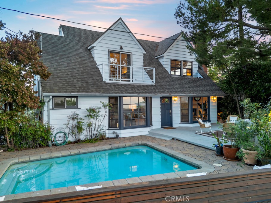 Rare. Iconic. Unforgettable. Nestled on a quiet, private street in legendary Laurel Canyon, this beautifully updated Cape Cod-style pool home blends classic charm with modern upgrades, offering a rare opportunity to own a true Hollywood Hills gem. With 3 bedrooms and 3 bathrooms, this spacious retreat delivers the perfect balance of privacy, character, and comfort for both everyday living and unforgettable entertaining. From the moment you arrive, you’re welcomed by an impressive entertainer’s front yard featuring a sparkling pool, custom bench seating, and a stunning pavered deck—ideal for lounging, hosting guests, or basking in the California sun. A peek of the Hollywood Sign adds an iconic touch to the serene canyon setting. Inside, refinished original hardwood floors and an open, airy layout set the tone for refined yet relaxed living. The formal living room flows effortlessly into a sunlit dining area, which opens to an oversized balcony with sweeping canyon views. The updated kitchen features granite countertops, stainless steel appliances, and a cozy breakfast nook—perfect for casual mornings or evening conversations. The main-level bedroom offers a private ensuite with stylish pebble flooring. Upstairs, the primary suite is a luxurious escape, featuring a spa-inspired bathroom with a custom soaking tub, lava rock steam shower, cedar-lined walk-in closet, and a private balcony. A third bedroom offers generous space and tranquil window views, ideal as a guest room, home office, or creative studio. Step outside to explore a terraced backyard complete with multiple levels and mature fruit trees—perfect for gardening, meditation, or simply enjoying the peaceful hillside landscape. Additional upgrades include a fully paid solar panel system, passive solar pool heating, copper plumbing, an upgraded electrical panel, tankless water heater, dual-pane windows and sliders, and a newer HVAC system. A two-car side-by-side garage completes the package. Ideally located just minutes from the Sunset Strip, Studio City, the Mulholland Tennis Club, scenic hiking trails, and within the sought-after Wonderland School District—this property offers both tranquility and convenience in one of LA’s most iconic neighborhoods. Come see this gem as this home is Priced to Sell!
