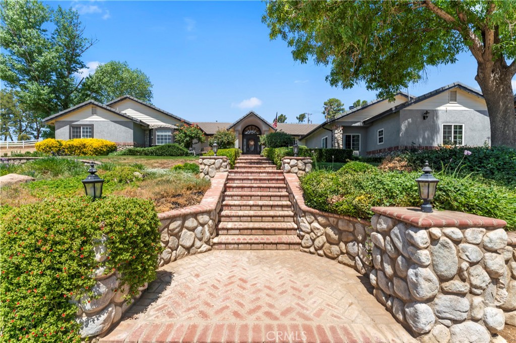 **Presenting an impressive Agua Dulce single-story country estate offering notable rental potential through separate guest quarters with private entrance, as well as an additional 800 sq. ft. of convertible space. This custom-built residence features a formal entry with leaded glass doors opening to a spacious, well-lit great room that seamlessly integrates dining and living areas. Ample storage is provided by hallway cabinetry, promoting organization throughout the home. The Primary Suite includes a double-sided fireplace, office nook, spa-inspired bath with granite counters, bespoke cabinets, freestanding tub, dual sinks, skylight, and tiled shower, designed for comfort and quality. Four supplementary bedrooms offer flexible accommodations for family or guests, along with updated bathrooms, including a Jack & Jill layout. A dedicated laundry room offers extensive linen and supply storage.
The gourmet kitchen is equipped with antique-style custom cabinetry, granite countertops, central island with breakfast bar, Viking appliances, double ovens, Sub-Zero refrigerator and freezer, and a walk-in pantry. A bright breakfast nook opens via French doors to the patio. Vaulted ceilings, a prominent fireplace, and luminous living and family rooms provide a gracious atmosphere for all occasions. An expansive 800 sq. ft. flexible space can serve as workshop, exercise room, craft area, or be converted to separate living quarters for added income. Garages for two and one cars include additional storage options.
Outdoor amenities include an illuminated tennis court convertible for pickleball, professionally landscaped grounds, productive well, solar panels, vinyl fencing, and RV facilities. The property demonstrates attention to detail and pride of ownership, combining comfort, elegance, and enduring appeal. For a detailed list of updates and amenities, refer to the Supplements tab and Virtual Tour. Solar payments are approximately $245 per month, with payoff in about 6.5 years. Buyers are advised to verify all information.