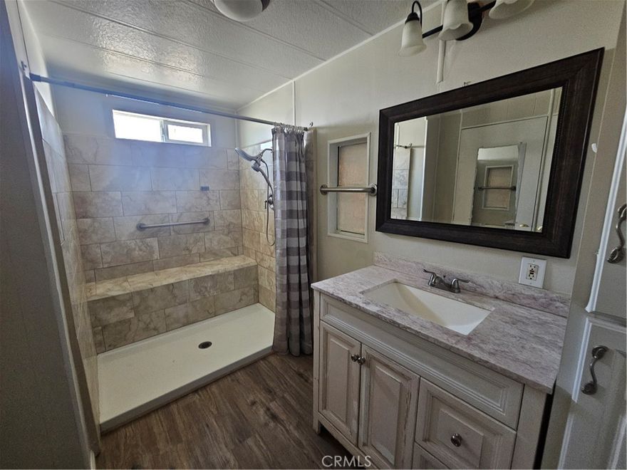 BEAUTIFUL UPGRADES in this charming, spacious 2 bedroom/1.75 bath home located in one of  San Jacinto's nicest +55 communities! All NEW paint inside and out, NEW laminate flooring throughout, NEW Primary bathroom with H-U-G-E walk-in tile shower, NEW lavy, sink and fixtures, separate dressing area and large walk-in closet. Laundry hook-ups inside, large bedrooms, dining room and ample sized living room. (Ser# A/B4949). This one is a "MUST SEE" before you buy anything else!