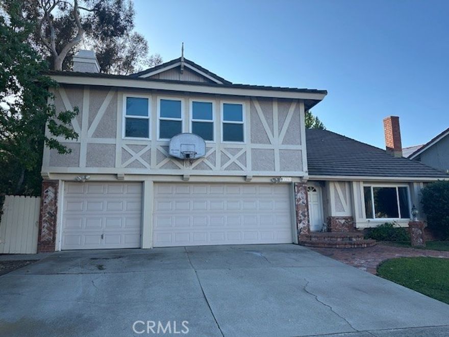 Welcome to this beautifully upgraded and exceptionally spacious Serrano Park residence, offering 3250 square feet of living space on a large lot adjacent to a lush greenbelt.  This delightful home features four generous bedrooms, including a luxurious primary suite and a convenient main-floor bedroom with a full bath - perfect for guests or multigenerational living. Large Formal Living Room with Fireplace, Formal Dining Room and a Family Room with fireplace overlooking large entertaining private backyard.  Kitchen offers granite counters and lots of counter and storage space.  Inside Laundry Room with washer/dryer and direct access to 3 car garage.  What everyone wants is a downstairs bedroom with a bathroom and walk-in shower.  Upstairs, a huge bonus room provides the ideal setting for a media area, game room, or home office. Elegant wood flooring extends throughout both levels, complemented by tile floors in the kitchen and bathrooms and soft carpeting on the staircase.  The kitchen and baths have been tastefully upgraded and updated, with the refrigerator, washer and dryer all included for added convenience.  Serrano Park residents enjoy resort-style amenities, including four lighted tennis courts, two sparkling swimming pools, scenic greenbelts, parks, picnic areas, playgrounds, and a sand volley ball court,  The neighborhood offers easy access to freeways, shopping, dining and more - making this home the perfect blend of comfort style and convenience.  Ready to make this your Home Sweet Home!