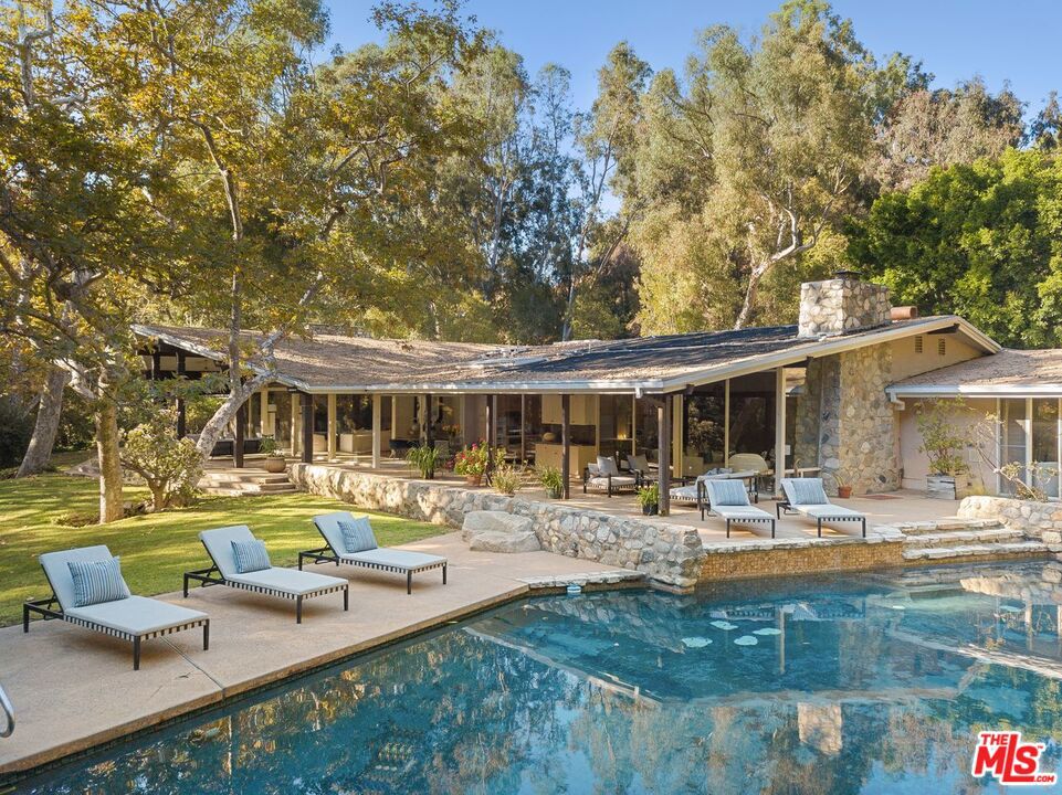 A rare and exceptional example of untouched mid-century modern style designed by critically acclaimed Architect William R. Stephenson AIA & built by Jack Straus. Stephenson was best known for designing the homes of several celebrities of Hollywood's Golden Age including the Pacific Palisades home of Ronald & Nancy Reagan. Located on the sought after & private road named Rivas Canyon right off Sunset Boulevard in the heart of Pacific Palisades area of Los Angeles. The house has 7 bedrooms, 5 baths, including the master wing with 2 bedrooms and an eastern wing with 4 guest bedrooms. There is an additional staff room with living area, bedroom & bath. Original 1960's condition, well maintained and a dream project for a decorators or designer. 4+ acres zoned for equestrian use with approximately 1.5 acres flat and directly connected via horse trails to Will Rogers Park. Interior photos with furniture are virtually staged.