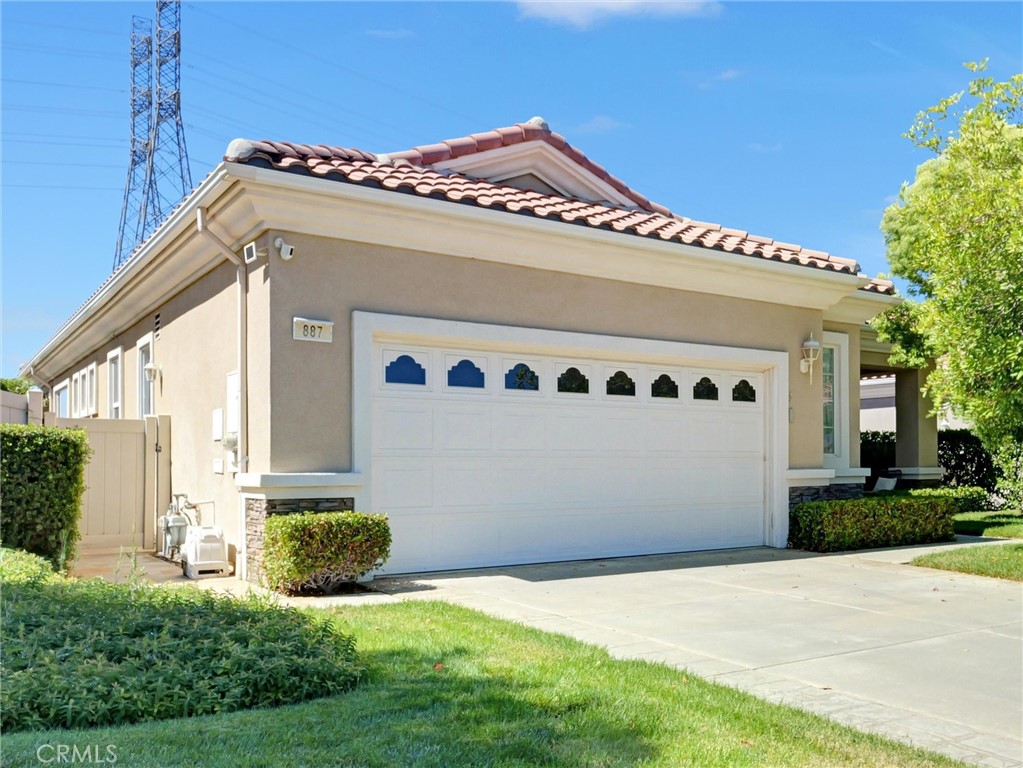 Welcome to 887 Westchester Rd. !!!!!!, This stunning home offers 1,687 square feet of luxurious living space in the highly desirable 55+ guard-gated community of Solera at Oak Valley Greens. This spacious single-story home features 2 bedrooms, 2 bathrooms, plus a dedicated TV room, offering both comfort and versatility. Step inside to a bright and open living space where comfort meets style. The spacious living room is anchored by a cozy fireplace and filled with natural light from expansive windows, creating the perfect setting for both relaxation and entertaining.
The dining area seamlessly connects the living and kitchen spaces, highlighted by a modern chandelier and plenty of room for gatherings with family and friends. The kitchen is a true centerpiece, featuring sleek white cabinetry, stainless steel appliances, and a large peninsula with bar seating—ideal for casual meals or hosting. Its open layout flows effortlessly into the dining and living room, making it the heart of the home.
The primary suite includes a large walk-in closet, dual sinks, a soaking tub, and separate shower. A spacious guest bedroom and full bath ensure comfort for visitors. The TV room offers flexibility for media, hobbies, or a cozy retreat.
Step outside to your own private retreat! This beautifully landscaped backyard features a covered patio with ceiling fan and string lighting, perfect for relaxing or entertaining guests year-round. The expansive lawn is surrounded by lush greenery, mature trees, and carefully manicured shrubs, creating a peaceful setting with both shade and open space. Decorative stonework and raised planters add charm and character, while the wrought-iron fencing provides an open view of the surrounding area. Whether you’re enjoying a quiet morning coffee, hosting a barbecue, or simply soaking in the tranquil atmosphere, this backyard is designed for both comfort and style.