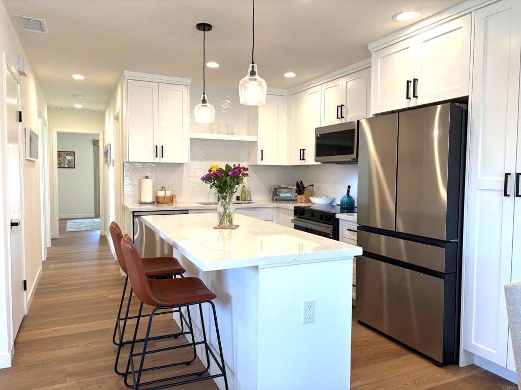 55+ Community - SHORT TERM RENTAL-2-4 Months. This completely remodeled home in the desirable HIGH COUNTRY VILLAS is single level with 3 bedrooms & 2 baths. It has been tastefully furnished with all new furniture and boasts lots of natural light. The kitchen has been designed with high end finishes that include stainless steel appliances, Carrera Quartz countertops, ceramic subway tile backsplash, a large island and hand crafted Shaker style white cabinets. Two patios include a private, fenced patio off the dining area that backs up to an open greenbelt. The second patio off the primary bedroom offers additional outdoor space. The floors throughout are beautiful wide planks in a french oak tone. Both modern bathrooms have been remodeled with a vertical subway tile shower, new white vanities and upgraded fixtures, mirrors and hardware in matte black. This lovely 55+ community offers two Pools and Spa area, 9-Hole Golf Course, Bocce Ball, Pickle Ball, Club House, Hiking Trails, Recreation room & more. The community offers both fun and relaxation and has an ideal location near beaches, shopping, & restaurants.