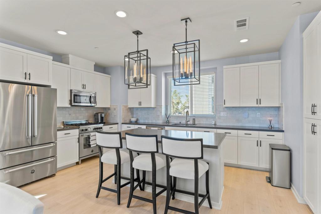 Experience the epitome of coastal luxury with this spectacular 3-bedroom, 3.5-bath townhome located west of I-5 and only a couple blocks to the beach! Situated in a coveted corner location, this property offers sweeping panoramic ocean views from its expansive rooftop deck—no need to look over other decks to take in the stunning coastline! Enjoy breathtaking sunsets as well as the surrounding mountains and city lights. Built in 2019, this home is thoughtfully designed with modern finishes and high-end upgrades. The spacious 1,951 sqft layout features a first-floor bedroom with a private full bathroom, ideal for guests or a home office. The open-concept second floor includes a gourmet kitchen with stainless steel appliances, quartz countertops, a large center island, and a sleek dining and living area that seamlessly flows onto a balcony—perfect for entertaining. The third floor boasts a luxurious primary suite with ocean views, a walk-in closet, and an impeccably upgraded en-suite bath with a large walk-in shower and double vanity. A second en-suite bedroom on the same level offers additional comfort and privacy. The highlight of this townhome is the stunning rooftop deck—complete with custom kitchen with barbecue, fire table, and ample space to host gatherings while soaking in the panoramic ocean views. Additional features include custom epoxy floor in garage, custom closets, custom garage cabinets, air conditioning, smart home controls with intercom iPads on each floor. Option to purchase completely furnished for an additional cost, so you can enjoy your new home right away!