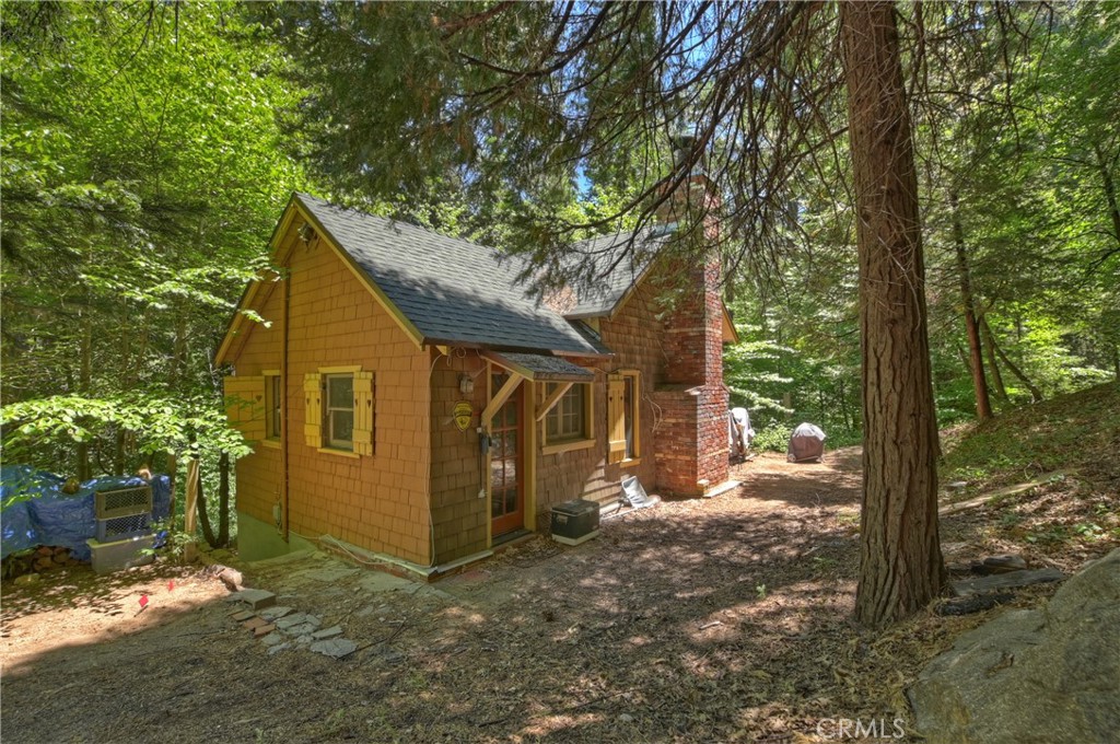 We call it Creek Side Cottage because you cross over the stream, on a bridge and it's right there. This Vintage cottage with original latch windows, wood floors vaulted open beamed ceiling and a real granite fireplace is currently being used as a writer's retreat, in that it is quiet and secluded. It's located in the highly coveted, gated community of Dogwood Blue Jay cyn, just minutes from the town of Blue Jay. The area is rare with a HOA that has its own wells and water system. 160 acres of green belt meanders around each property, providing a private forest feeling. _____________________________________________________________________________________