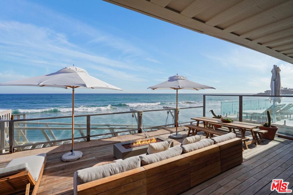 Beachfront Luxury Lease. Available August 7, 2025. Discover unparalleled coastal elegance in this fully remodeled (2025) 3-bedroom, 3-bathroom masterpiece on iconic Broad Beach Road, designed for up to 8 guests. This luxurious beachfront retreat blends sophisticated design with relaxed oceanside living, offering breathtaking ocean views and direct private beach access. Key Features: Stunning Great Room: Step into an airy, open-concept living space with soaring glass ceilings, European oak flooring, and panoramic Pacific Ocean vistas. Relax on the plush sectional sofa with a 98" smart TV or gather by the fireplace in the cozy secondary sitting area with a sofa and armchairs. Gourmet Kitchen: A chef's dream featuring Italian oak cabinetry and top-tier Gaggenau appliances, including an induction cooktop, refrigerator/freezer, double oven with microwave, dishwasher, and wine fridge. Perfect for preparing meals to enjoy at the 10-foot teak dining table, seating 12. Expansive Outdoor Deck: Seamlessly connected to the interior, the deck boasts a natural cedar hot tub, large gas fire pit, barbecue, teak dining table, and ample lounging areas, all steps from the sandy shores of Broad Beach. Luxurious Primary Suite (Second Floor): A private sanctuary with a balcony featuring comfy lounge chairs, an oversized spa bathroom with plaster walls, a limestone soaking tub, a double-headed shower, Italian oak cabinetry, a walk-in closet, an 85" smart TV, and a fireplace seating area. Guest Bedrooms (First Floor): Two thoughtfully designed bedrooms with two queen beds, the other with one queen bed, both with access to a stylish bathroom featuring a walk-in shower, plaster walls, and Italian oak cabinetry. A separate powder room with alabaster lighting adds convenience.Premium amenities include a detached two-car garage with washer/dryer, back-up power battery, and EV charger. The home is equipped with top-of-the-line fixtures, finishes, and smart home technology throughout. Experience Coastal Bliss. This beachfront gem offers the ultimate indoor-outdoor lifestyle, combining modern luxury with the serene beauty of Broad Beach. Whether soaking in the hot tub, dining al fresco with ocean waves as your backdrop, or unwinding in the spa-inspired primary suite, every moment here is designed for relaxation and indulgence. Available for lease starting August 7, 2025. Don't miss the chance to call this fabulous retreat your home by the sea.