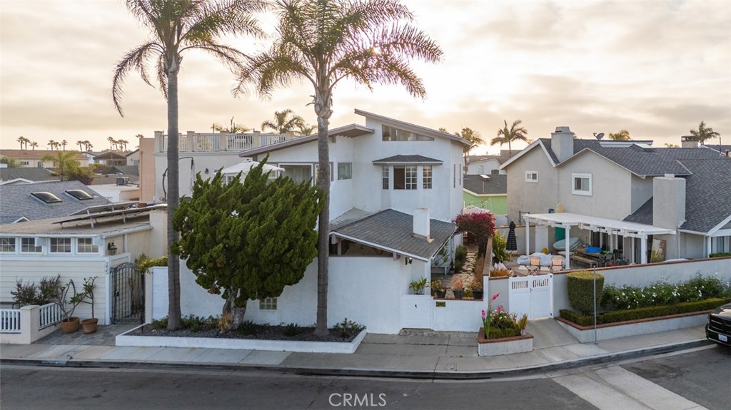 Welcome to 259 62nd Street, on the market for the first time in 40 years. This 4-bedroom, 4-bathroom home spans 2,184 square feet and sits on a larger-than-average lot in the coveted Newport Shores community. Just across Pacific Coast Highway from the beach, this property is a must-see. The spacious living room is filled with natural light and features vaulted beamed ceilings, high windows, and a cozy fireplace. The kitchen is outfitted with granite countertops, a gas range, and a breakfast bar, perfect for everyday living and entertaining. The expansive primary suite offers a private deck, office space, and an attached bath with a soaking tub and a walk-in closet. A generous upstairs bonus room and loft provide flexible living space to suit a variety of needs. One of the home’s standout features is its beautiful canal view, an exceptional and rare offering for properties not located directly on the water. The fourth bedroom features its own private entrance, offering a comfortable and private setting for visiting guests or an older child seeking more independence. Downstairs, one of the two main floor bedrooms includes an ensuite bath and a private patio, making it a potential second primary suite. The backyard is a charming coastal retreat, complete with a brick patio ideal for outdoor dining or relaxing. A flower-covered wood archway creates a welcoming and picturesque transition from the home to the yard space. Additional features include seller-owned solar panels for energy efficiency and a two-car garage with convenient alley access. Nestled along a tranquil canal, Newport Shores offers a unique homeownership experience focused on outdoor living and a tight-knit, family-friendly community. Residents enjoy access to a waterfront clubhouse with a lap pool, tennis and basketball courts, beach volleyball, and a BBQ and picnic area. Just across PCH from one of Newport’s best beaches, you’ll have ample space to relax, tan, or enjoy the Pacific Ocean. The neighborhood is within walking distance to beloved local spots including restaurants, coffee shops, and the iconic Frog House Surf Shop, and just minutes from the harbor, Bayfront dining, Lido Marina Village, Cannery Village, Hoag Hospital, and the award-winning Newport-Mesa Unified School District.