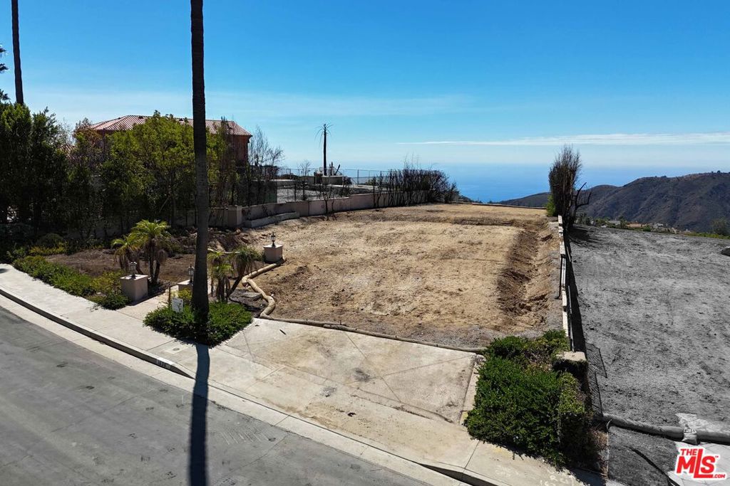 This 10,192-SF lot sits within the prestigious neighborhood of The Summit of the Palisades Highlands, showcasing sweeping views of the ocean, canyons, and mountains. The prior residence was a 5,307-SF, 5-bedroom, 5-bath home, providing a substantial footprint for rebuilding. Owners enjoy access to the recently re-opened Summit Club, featuring resort-style amenities such as tennis courts, a clubhouse, gym, basketball court, playground, pool, and spa. Ideally located near beaches, hiking trails, and just minutes from Palisades Village. Phase 1 EPA remediation and Phase 2 debris removal by the Army Corps of Engineers are complete, offering a ready opportunity to design and build your dream home.