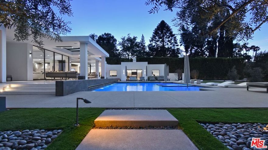 Extraordinary single-story Tennis Court estate on one flat acre in prime Royal Oaks. This newer build contemporary masterpiece is incredibly sleek and sexy-it truly is Trousdale in Encino. Custom architectural design has pristine Terrazzo floors throughout. Walled, gated, and surrounded by mature hedging, the home is set deeply off the street for maximum privacy and security. Perfect for sophisticated entertaining. Huge motor court for the car collector houses 8 cars, plus multiple additional spaces for guests. The gorgeous living room seamlessly flows to the chef's kitchen with top-of-the-line appliances adjacent to an impressive dining room. Floor-to-ceiling glass Fleetwood doors which wrap around the sweeping property allow you to fully open and live your dream indoor-outdoor lifestyle. The main bedroom feels like the ultimate 5-star hotel suite. Gorgeous dual walk -in closets, black-out shades, radiant heated flooring in a bathroom flooded with natural light. A great media room, a voluminous wine storage room, and the separate guest wing accommodate a killer office and gym. The outdoor kitchen with covered patio features heaters and disappearing glass doors that make the entire property flow.