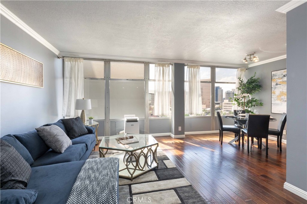 Located in the iconic Royal Palms building in the heart of Downtown Long Beach, this stylish 1-bedroom, 1-bathroom condo offers 600 sq. ft. of modern living with sweeping Cityscape and skyline views that dazzle both day and night. The bright, open living and dining areas feature wall-to-wall windows and laminate flooring throughout, while the updated kitchen showcases stone countertops, glass tile backsplash, and included appliances. This all-electric unit (no gas) provides comfortable and efficient living, complemented by the convenience of a secure building with professional management, staffed lobby office, 24-hour camera surveillance, swimming pool, and onsite community laundry. The monthly HOA covers water, trash, sewer, and more, making this a worry-free lifestyle. Enjoy being just steps away from a grocery store, top-rated restaurants, coffee shops, bakeries, and breweries, plus only minutes from the beach, The Pike, Shoreline Village, the Aquarium of the Pacific, the Queen Mary, and the Convention Center. Whether as your full-time residence or an investment, this condo combines mid-century charm, modern amenities, and an unbeatable location.