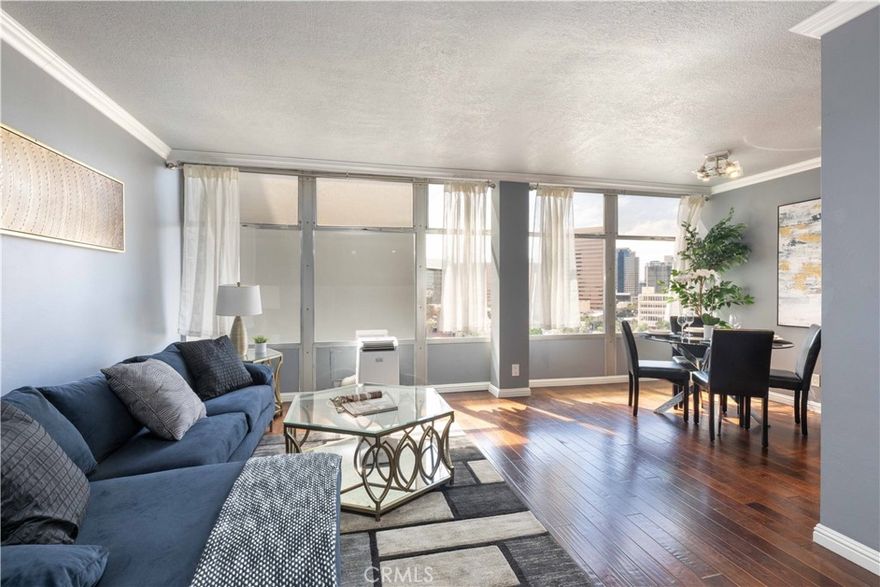 Located in the iconic Royal Palms building in the heart of Downtown Long Beach, this stylish 1-bedroom, 1-bathroom condo offers 600 sq. ft. of modern living with sweeping Cityscape and skyline views that dazzle both day and night. The bright, open living and dining areas feature wall-to-wall windows and laminate flooring throughout, while the updated kitchen showcases stone countertops, glass tile backsplash, and included appliances. This all-electric unit (no gas) provides comfortable and efficient living, complemented by the convenience of a secure building with professional management, staffed lobby office, 24-hour camera surveillance, swimming pool, and onsite community laundry. The monthly HOA covers water, trash, sewer, and more, making this a worry-free lifestyle. Enjoy being just steps away from a grocery store, top-rated restaurants, coffee shops, bakeries, and breweries, plus only minutes from the beach, The Pike, Shoreline Village, the Aquarium of the Pacific, the Queen Mary, and the Convention Center. Whether as your full-time residence or an investment, this condo combines mid-century charm, modern amenities, and an unbeatable location.