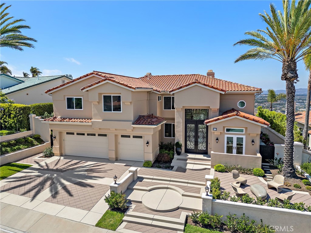 Refined Coastal Living in Guard-Gated Palmilla, Laguna Niguel
Commanding a premier front-row position in the prestigious guard-gated enclave of Palmilla, this newly reimagined semi-custom estate offers a rare opportunity to experience elevated living in the coveted heights of Niguel Summit. Encompassing approximately 4,431 square feet on a generous 8,500 square foot lot, this distinguished residence features 4 ensuite bedrooms, 4.5 baths, and sweeping panoramic views of Saddleback Mountain, enhanced by cool ocean breezes from nearby Laguna Beach.
An impressive arrival begins at the 12-foot custom iron entry doors, opening into a voluminous interior defined by 18-foot ceilings, Spanish tile flooring, and dramatic floor-to-ceiling windows that flood the home with natural light while framing tranquil city and mountain vistas.
The flowing floor plan connects formal and casual spaces with effortless elegance. Anchoring the main living area is a contemporary smart fireplace, seamlessly adjoining a designer chef’s kitchen appointed with bespoke Italian cabinetry, Taj Mahal quartz countertops, Thermador appliances, and Italian lighting. Wellness and function converge at the sink with an instant hot water tap and reverse osmosis filtration system.
A full ensuite bedroom on the main level offers ideal accommodations for guests or multi-generational living. French doors invite you outdoors to a private and professionally landscaped backyard, thoughtfully enhanced with new pavers and abundant space for alfresco dining and entertaining.
Ascending a staircase finished in custom redwood, the upper level reveals three additional ensuite bedrooms and a versatile bonus room, ideal as a home office, media lounge, or fitness studio. The expansive primary suite captures dazzling city light views and features a serene sitting area with a dual-sided smart fireplace, shared with the spa-inspired primary bath—complete with heated porcelain floors, Italian cabinetry, designer lighting, and a custom built-in wardrobe.
Additional enhancements include new HVAC systems, updated plumbing and electrical, dual-pane energy-efficient windows, epoxy-coated garage flooring, and smooth stucco exterior finish.
Situated minutes from renowned beaches, scenic trails, top-tier schools, and upscale dining and boutiques, this exceptional residence combines the finest in luxury design, modern comfort, and coastal California living.