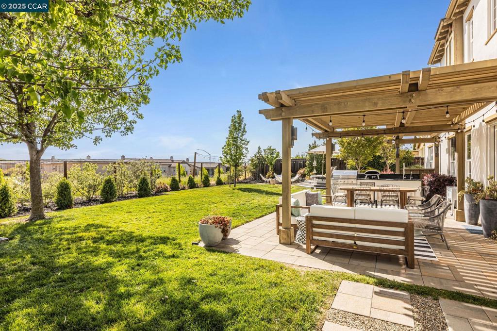 Stunning showcase home with an impressive blend of luxury & functionality, 4,255 Sq Ft of meticulously designed living space on a large 11,637 Sq Ft lot (.27 Acre) with views! Wide-plank wood floors & designer lighting featured throughout this spacious home. Versatile main floor guest wing w/option of 6th bedroom. Main level has a guest bedrm, 1.5 baths, & office w/French doors that open to a private courtyard, complete w/cozy fireplace. The heart of the home is an open concept great room, seamlessly integrating the kitchen, family rm w/ fireplace & dining areas. The kitchen boasts marble countertops & high-end SS appliances, an inviting space for both day-to-day living & entertaining. French doors lead to a charming courtyard & large backyard oasis, enhancing indoor-outdoor flow. Formal living rm has bay window, built-in cabinets & fireplace. Formal dining room for entertaining. Primary suite offers a retreat & sweeping views. Spa-like bath w/ dual sinks/vanities, dressing areas & 2 walk-in closets. Step outside to a beautifully landscaped backyard w/ tons of room for entertaining w/outdoor kitchen, bocce court, play area, expansive lawn, hot tub, fire pit, veggie garden, fruit trees & views. No rear neighbors. Walk to pool/cabana, and K to 8th grade at award winning schools!