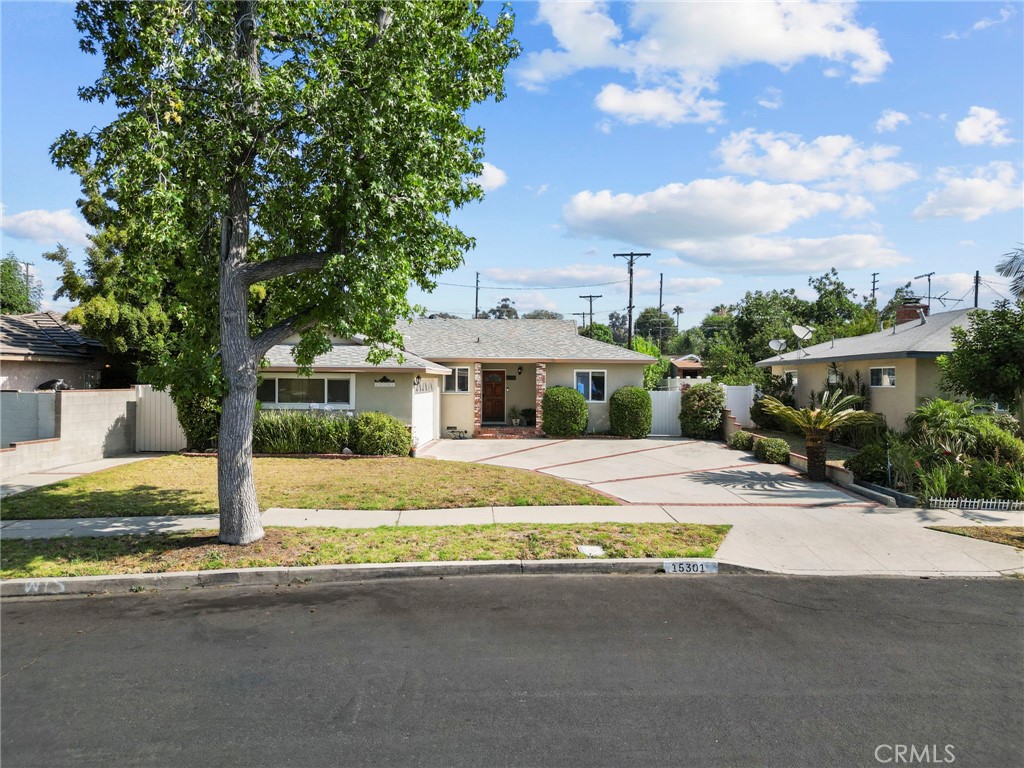Beautiful 3+2 home in a lovely tree lined neighborhood! With a large, oversized, brick inlaid driveway, step onto the porch and into the home with refinished wood flooring, and smooth ceilings throughout, a large living room featuring remodeled gas fireplace with designer mantel and stacked stone, crown molding, and recessed lighting. Dining area off of the kitchen with direct garage access which features a finished 2 car garage with washer/dryer, sink and tankless water heater. Kitchen features upgraded granite counters with tile backsplash, natural wood cabinets, recessed lighting, portable island with butcher block counter, and tile flooring. Head down the hallway to the primary bedroom with vinyl windows, mirrored closet doors, and newer ceiling fan, bathroom features newer vanity, and beautiful upgraded tiled shower. Gorgeous, modern remodeled hall bath with large shower and beautiful vanity! Bedroom 2 features vinyl windows, newer ceiling fan, mirrored closet doors and a door to patio with security gate. Bedroom 3 features vinyl windows, raised panel closet doors and newer ceiling fan. Large backyard with possible ADU opportunity with direct access on side yard! Patio with vinyl cover and ceiling fan, newer vinyl fencing, and newer wood fencing on back wall. Beautiful lemon trees and plants offer a cool, lush feeling with lovely string lighting! Central heat and air, newer house paint, all upgrades completed within the last 5 years. Close to shopping, freeway access & transportation!