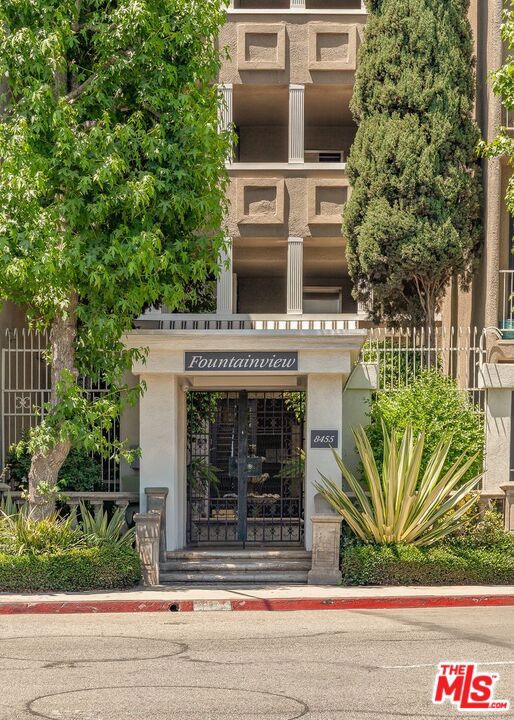 Welcome to this luxurious and spacious 2BD/2BA home in one of the area's most desirable communities. From the formal entry with custom console and mirror to the smart lighting and rich wood floors, every detail is thoughtfully designed.Enjoy a center-hall layout with a large living room featuring a fireplace, built-in bar, and beverage fridge. The chef's kitchen boasts granite countertops, Samsung appliances, Kitchenaid dishwasher, and custom cabinetry, plus a cozy breakfast nook and formal dining area that opens to a private balcony.The primary suite offers a second fireplace, remodeled en-suite bath, and walk-in closet with built-ins. A spacious secondary bedroom, remodeled guest bath, in-unit laundry room, and only one shared wall enhance privacy and function. Unit includes 2-car tandem parking by the elevator. Community amenities: gated entry, 3-story waterfall, pool, spas, gym, library, billiards, and updated elevators. Easy garage access from both Fountain Ave and La Cienega Blvd.Live in luxury, comfort, and convenience all on one floor.
