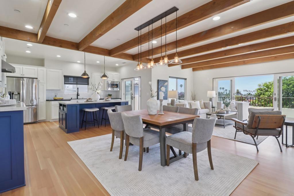Welcome to this beautifully updated 2016 built Irving Gill inspired Prairie Revival Style home with breathtaking Sea World and mountain views, as well as a peek-a-boo ocean view. This light-filled, open-concept residence is designed for modern living with high ceilings, exposed beams, and a cozy gas fireplace, creating a perfect blend of elegance and comfort. The spacious kitchen is a chef's dream, featuring marble and quartz countertops, a stylish SMEG range/oven, a farm sink, high-end fixtures and plenty of storage space. Newly refinished wood floors add warmth and charm throughout the home, while Anderson "quiet" windows and wood plantation shutters provide both privacy and tranquility. The main level offers a luxurious primary bedroom with French doors that open to a private deck, perfect for enjoying the ocean breeze. Two additional bedrooms are located downstairs, alongside a versatile open area that can be used as an office, extra living space or could be converted into a fourth bedroom if desired. The home also features a basement that is over 1,000 SF with lighting, electric and ample storage, offering endless possibilities for organization. Step outside and enjoy the expansive decks off both the living area and primary bedroom, along with a spacious downstairs patio and backyard featuring a large grass area, fruit trees, and a third deck — ideal for outdoor relaxation and entertaining. Additional highlights include owned solar panels, electric vehicle charging capabilities, a newer washer/dryer, and an elevated location that captures refreshing ocean breezes. This home is conveniently adjacent to Collier Park and a native plant garden, and is only about 1 mile from the beach, offering the perfect combination of serene nature and coastal convenience. Don’t miss the opportunity to make this stunning home yours!