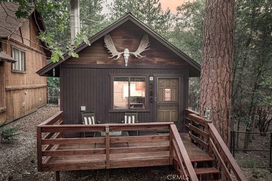 Welcome to 790 Pine Lane—your perfect mountain retreat nestled on a spacious 4,750 sq. ft. double lot in the heart of Sugarloaf. This cozy single-story cabin offers the ideal blend of rustic charm and modern updates, with room to expand or simply enjoy extra outdoor space. Step inside and feel the warmth of the tongue & groove walls and knotty pine vaulted ceilings. The open-concept layout combines the kitchen, dining, and living areas, centered around a beautiful rock fireplace—perfect for cozy evenings. Recent upgrades include new flooring, updated bathroom vanity, updated light fixtures, and modern electrical outlets throughout, adding convenience and style to the classic mountain feel. The cabin offers two comfortable bedrooms, including a rear bedroom that opens to a private deck—an ideal spot to enjoy peaceful mornings surrounded by towering pines and fresh mountain air. Additional highlights include laundry, front and rear wood decking, a fully fenced yard, a newer roof, and fresh paint. Pride of ownership is evident throughout—this cabin is move-in ready and fully furnished, so all you need to do is hang up your clothes and start enjoying. **The adjacent vacant lot included in this sale has its own APN, providing an excellent opportunity to build a second cabin or sell the parcel separately for added value and flexibility. Located just a few hundred feet from the National Forest, this is an outdoor lover’s dream. Whether you’re looking for a full-time residence, a weekend escape, or a smart investment property, this is a rare opportunity to own a well-cared-for cabin on a double lot in a serene and beautiful location.