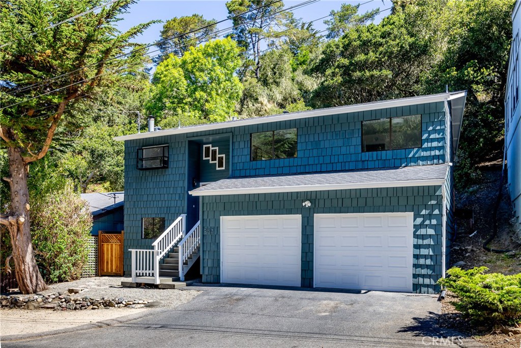 In the West Village of Cambria Pines by the Sea, on a quiet street just steps from shops, restaurants, wine and beer tasting is 953 Sheffield St. This home, set on a quiet culdesac, offers 4 bedrooms and 3 bathrooms extensively remodeled including flooring, windows and kitchen and baths updated with all new fixtures, cabinets and countertops! On the bright and cheerful main level you have 3 bedrooms including the generous main suite, 2 bathrooms, and the open living, dining and kitchen and ample-sized deck. In the kitchen you get brand new stainless steel appliances, quartz counters on the new cabinetry. The living and dining offers volume with vaulted ceilings, and a stone corner fireplace and an adjacent deck for indoor/outdoor living. There is a horizon ocean view from this level too. The oak trees behind the deck create a perfect setting for morning coffee or evening sunsets with a glass of wine. The 2 guest bedrooms have peaceful views of Monterey Pines and oaks. Downstairs is a guest suite, similarly updated, laundry/utility room, and an attached 2 car garage. Moonstone Beach Drive is a short walk, with a few coffee shops on the way. Village life with minimal driving required is available here. Call your Realtor to see this move in ready home, whether for vacation getaways or full time living.