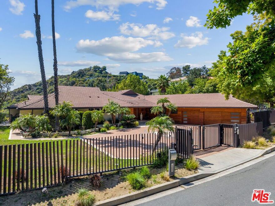 FAMILY TRUST AUCTION. Set behind gates on a serene street in coveted Trousdale Estates, 405 Evelyn Place presents a rare chance to reimagine or rebuild on one of the enclave's most desirable parcels. Positioned on a generous 20,488-square-foot (.47 AC) lot with a mostly flat pad, this exceptional property offers the scale, privacy, and orientation to craft a world-class modern estate in one of Beverly Hills' most iconic neighborhoods. From its elevated vantage point, the property captures awe-inspiring canyon and mountain views that stretch westward -- delivering a tranquil, cinematic backdrop for California's famed indoor-outdoor living. Mature greenery surrounds the site, while a gated motor court and expansive grounds add to its estate-like presence. The existing single-level home, originally built in 1960, spans approximately 3,730 square feet and includes five bedrooms, seven bathrooms, multiple entertaining areas, and an attached three-car garage. Large picture windows frame sweeping vistas, and a pool and spa anchor the outdoor entertaining space -- ideally positioned to showcase the lush canyon below. Whether envisioned as a ground-up legacy estate or a thoughtfully reimagined residence, 405 Evelyn Place offers major potential in a location known for its prestige and exclusivity -- mere moments from the heart of Beverly Hills yet quietly tucked away.