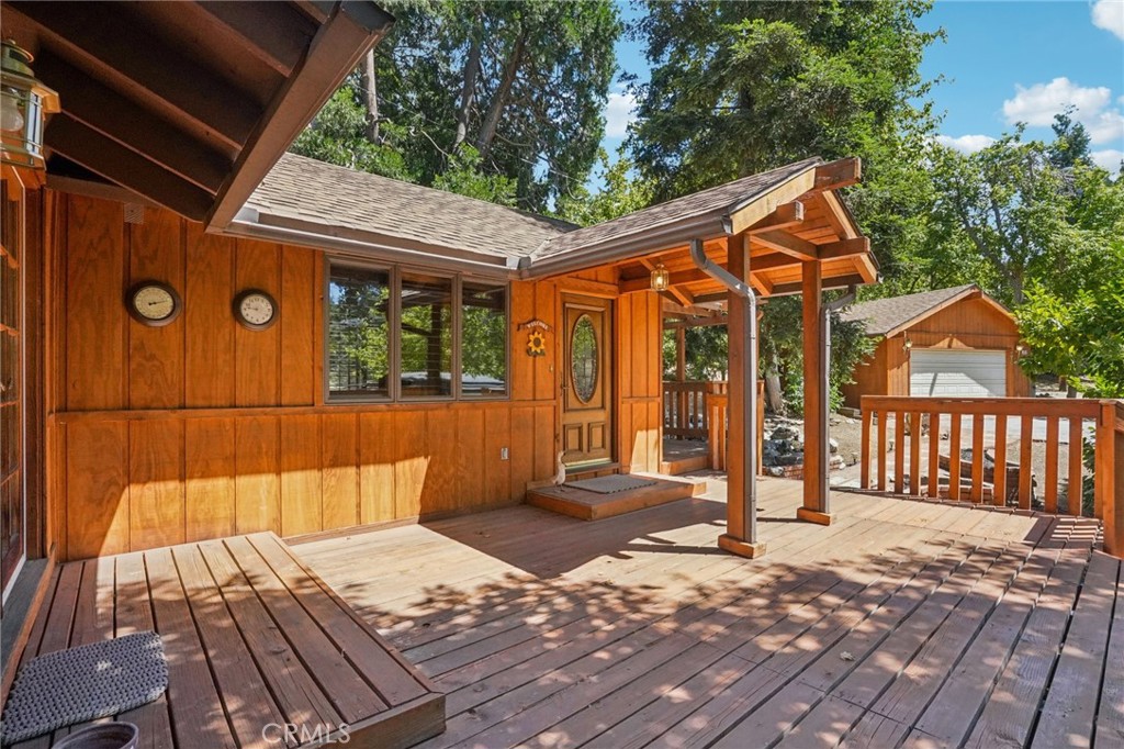 Absolutely charming Oak Glen cabin near iconic apple orchards, boutique shops, and quaint restaurants. This well-maintained property features 1 bedroom and 1.75 bathrooms in 1,052 sq. ft. of living space, all situated on a private 15,300 sq. ft. lot with plenty of space for home expansion if desired. Also offering a detached 2-car garage, a 1-car carport, and driveway parking for 4 additional cars - great for guests! A lovely brick walkway with planters adorns the front, leading to the front deck which wraps around the home to the back. Inside, you will find beautiful vaulted wood-beamed ceilings, wooden plantation shutters, central A/C & heating, and newly installed aluminum flex ducting (rodent resistant) under the home! The home boasts a spacious living room complete with wood-burning stove. The living room flows into the kitchen with wood cabinetry, tile counters, and high-end Bosch Stainless Steel appliances including the cooktop with vent, a built-in oven, and microwave. The Samsung refrigerator is also included with the sale of the home! The kitchen opens to the light and bright dining room with double French-doors that opens to the front deck, and there is a convenient laundry closet in the kitchen with included washer and dryer. This home has a large bedroom with glass slider to the back deck, a large private ensuite with vanity space, a walk-in shower, and the ideal cedar-lined walk-in closet with built in storage. A full-size bathroom completes the interior floor plan. Relax and entertain on the back deck with stunning mountain and forest views, and there is also a shed for extra storage! This home is truly a gem! Bask in the best of mountain living while still being close to shopping and services, also the US Forestry Service Station is located next door! Do not miss this one!