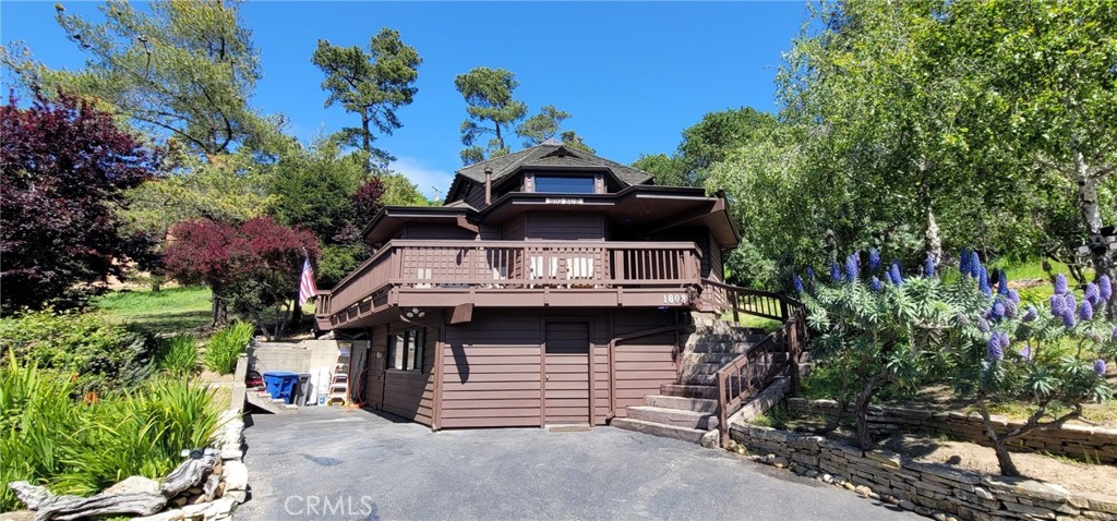 Big Sur style custom built Lodge Hill Hideaway. A Licensed Vacation Rental! Wood interior with Cedar beams, partial glass ceiling, skylights and Shoji screens throughout. Wooded views and wrap around deck for outdoor enjoyment. There are three bedrooms & two bathrooms and a wood burning stove in living area with built in seating. Private sunny backyard patio provide outdoor living space. Indoor laundry in lower storage room/possible workshop or living area. Appliances and a soft water system included. Enjoy peace and quiet where wildlife abounds. Offered for $899,000.