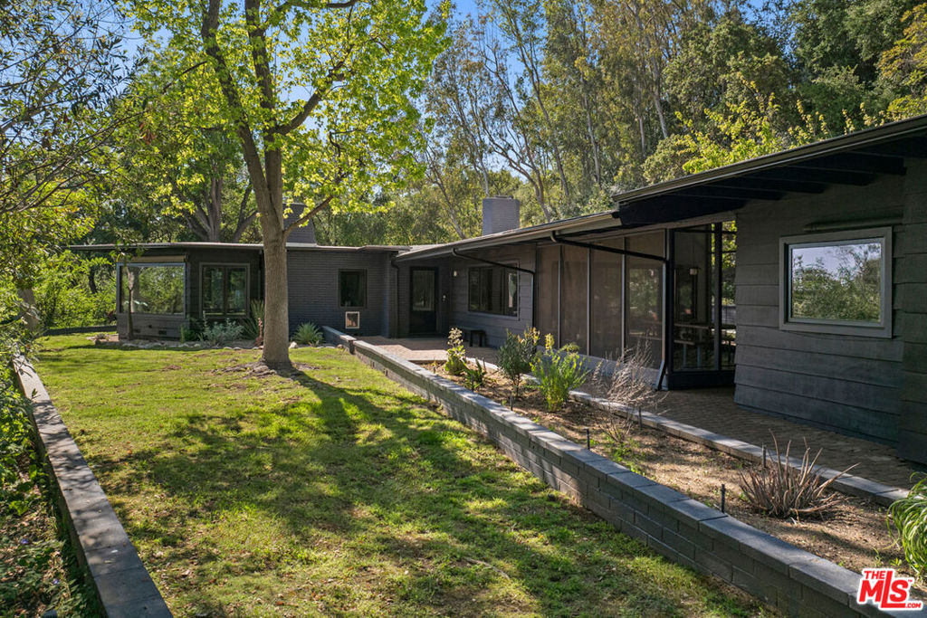 Tucked into the foothills of the San Gabriel Mountains, this beautifully updated Mid-Century retreat offers space, privacy, and everyday ease on nearly 1.5 acres in exclusive Kinneloa Mesa. Designed for the way you live, the open layout flows easily from airy interiors to lush outdoor spaces. The expansive residence features beamed ceilings, wood detailing, and oversized windows that fill the home with light; the sunroom is an airy spot for reading or playtime. Cooking and entertaining are easy in the renovated kitchen with Wolf range, butcher block island, and wine fridge. Four bedrooms provide space to unwind and grow, including a large primary suite with garden access. The converted garage is ready for your gym or studio, with a basement for storage below. Alfresco dining and sauna soaks are just some of the pastimes to enjoy in the rambling grounds of your private escape, minutes from hiking trails, the Pasadena farmers' market, and a variety of shops and restaurants.