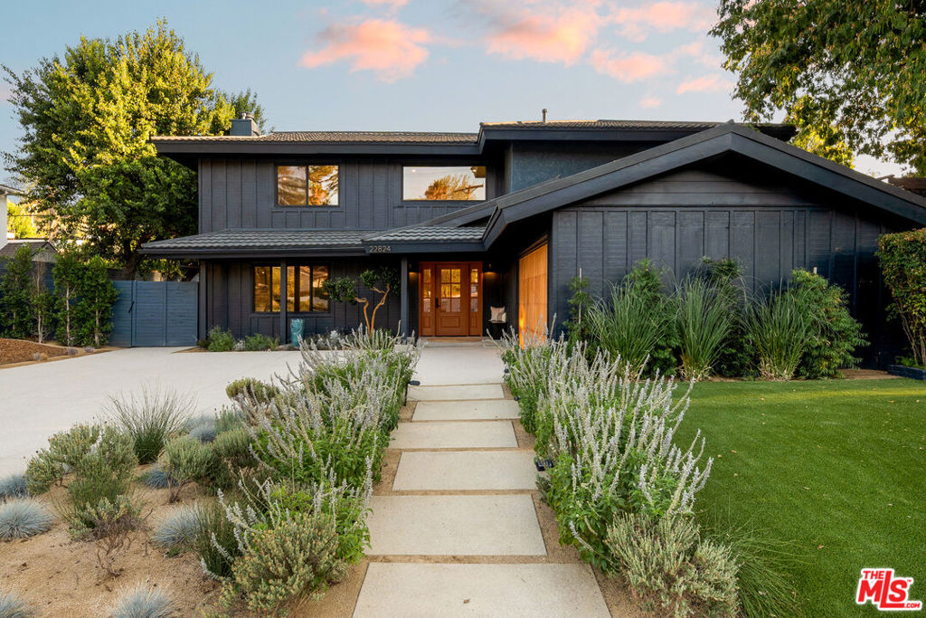Tucked away on a serene, tree-lined street south of the Boulevard, this newly remodeled two-story estate blends timeless California charm with refined modern luxury. Thoughtfully curated for elegant family living and effortless entertaining, the 5-bedroom residence sits on an expansive, private lot adorned with lush, mature landscaping and high-end amenities at every turn. A tranquil water feature and smart-controlled landscape lighting frame the striking curb appeal, inviting you into a warm, light-filled interior. The grand living room features an arched wood-burning fireplace finished in natural plaster and flanked by bespoke built-ins, setting the tone for the home's artful design. At the heart of the home lies the custom chef's kitchen, an entertainer's dream, complete with rich wood cabinetry, walk-in pantry, water filtration system, luxury Forno appliances, and a showstopping lilac marble island. Designed for seamless indoor-outdoor flow, the family room opens to an expansive resort-style backyard oasis. Entertain under the barn wood trellis in the oversized outdoor kitchen and dining area, unwind by the custom heated pool, or perfect your short game on the private putting green. A full outdoor bathroom with natural stone, slip-resistant flooring ensures comfort and convenience for guests and poolside living. Upstairs, you'll find five versatile bedrooms, including a serene primary retreat with a spacious walk-in closet and a spa-like en-suite bath with dual rainfall showers. Two additional bedrooms offer comfortable proportions, while the two rear bedrooms provide ideal flexibilityperfect as home offices, guest quarters, or creative studios. A dedicated laundry room and additional utility space offer everyday practicality, while wide-plank hardwood floors, imported European tiles, multi-zone HVAC, and a durable metal roof provide modern comfort and long-term value. With its blend of sophistication, warmth, and functionality, this exceptional home is ideal for growing families or those who love to entertain in style. Located moments from top-rated schools, local markets, and premier shopping, and just minutes from Calabasas, this is Woodland Hills living at its finest.