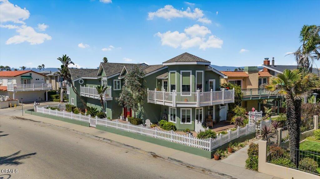 This fabulous beach home offers over 3,000 sq ft of beautifully maintained living space, featuring a unique floor plan ideal for multi-generational living, roommates, or hosting guests. The upper level includes a spacious primary suite with a beautifully remodeled bathroom and walk-in closet, a gourmet kitchen, an elegant dining room, and a large living room with a cozy fireplace and stunning ocean views from both the living room and the decks. Multiple decks extend from the dining room, living room, and primary bedroom, creating seamless indoor-outdoor living. Downstairs, you'll find two generously sized bedrooms, a welcoming family room with its own fireplace, and a wet bar area perfect for entertaining. The home also features a great yard with a tranquil koi pond, newer windows throughout, fresh interior and exterior paint, newer hardwood flooring upstairs and on the stairwell, and stonelike walkways, and garage doors. The 3-car garage includes one bay currently converted into a home office. Located just steps from the beach, this home offers the perfect blend of comfort, flexibility, and coastal charm.