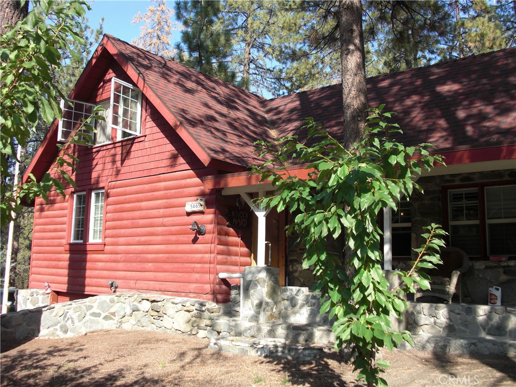 One of Wrightwood's old beauties. This one sits on a double lot with a circular drive. Garage is in the basement level. This one was modified to be handicap accessible with a main bedroom downstairs. Kitchen is open concept with a dual oven. Living room is designed to be an in-house theatre. There is also a game room with a pool table. Upstairs are three bedrooms. According to the owner, the house was upgraded ten years ago. Included in that were the new living room, a whole house forced air system. All the windows have been upgraded to new dual pane and shutters. There is also a water softener system and demand water heater.