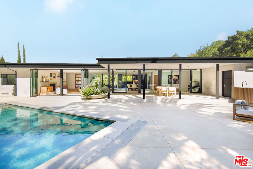 Nestled in the tranquil hills of Benedict Canyon, this reimagined 1970 contemporary modern estate is a rare sanctuary of privacy, sophistication, and indoor - outdoor California living. Set on a quiet cul-de-sac in one of LA's most coveted enclaves, the 6 bedroom, 7 bathroom residence spans 4,810 feet ( includes garage) of thoughtfully designed interiors and breathtaking outdoor escapes. Designed for effortless elegance, the home features two private primary suites - perfect for multi-generational living or lavish guest stays-along with a chef's kitchen appointed with Thermador and Viking appliances. Smart home tech, full solar power with backup generator, a custom theatre, and a state-of-the-art gym ensure modern conveniences and sustainable luxury. Outdoors, experience your own private resort: drought-tolerant landscaping surrounds a sparkling pool and spa, a pickle-ball ready sport court, and multiple alfresco lounges ideal for sunset entertaining. With ample parking, impeccable le design, and ultimate seclusion-this is more than a home. It's a statement of lifestyle, in a location that defines prestige. Roof was replaced in 2024. The residents who live on Liebe also have a security patrol on their street paid by one of the residents ( per seller)
