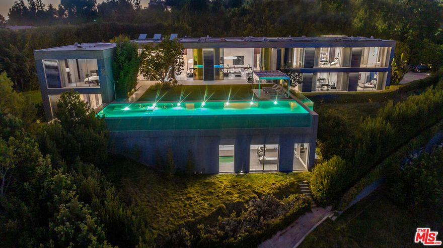 DO NOT CONTACT SELLER - HOME IS RE-LISTED! Exceptional Contemporary Estate Ideally located in the highly coveted lower Bel-Air at the end of the cul-de-sac! This architectural masterpiece by Marmol Radziner and Felicity Bell epitomizes modern luxury and European sophistication. Spanning over 14,000 square feet and offers unparalleled privacy and grandeur. This ultimate estate greets you with a spacious motor court and lush landscaping. Entry opens to a sky-lit gallery, leading into an expansive floor plan featuring dramatic 24-foot ceilings and a seamless flow of natural light. Floor-to-ceiling Fleetwood glass doors create a harmonious connection between the interior and the breathtaking outdoor spaces.  The formal living areas include a dual fireplace that divides the living and dining rooms, both designed for showcasing art collections. Each of the seven-bedroom suites boasts glass walls and spa-inspired bathrooms, offering serene views of the Bel-Air Country Club and the surrounding canyons. Luxury amenities include an indoor lap pool and wellness center, a state-of-the-art chef's kitchen, a dedicated art studio, and formal staff quarters. The estate's outdoor spaces are equally impressive, featuring a sprawling lawn, an infinity-edge pool, and a cabana/sunbathing deck. The entire structure is made entirely out of concrete! This estate is a testament to meticulous craftsmanship, extraordinary quality and a high level of sophistication, making it a rare opportunity for those seeking an unparalleled living experience in Los Angeles.