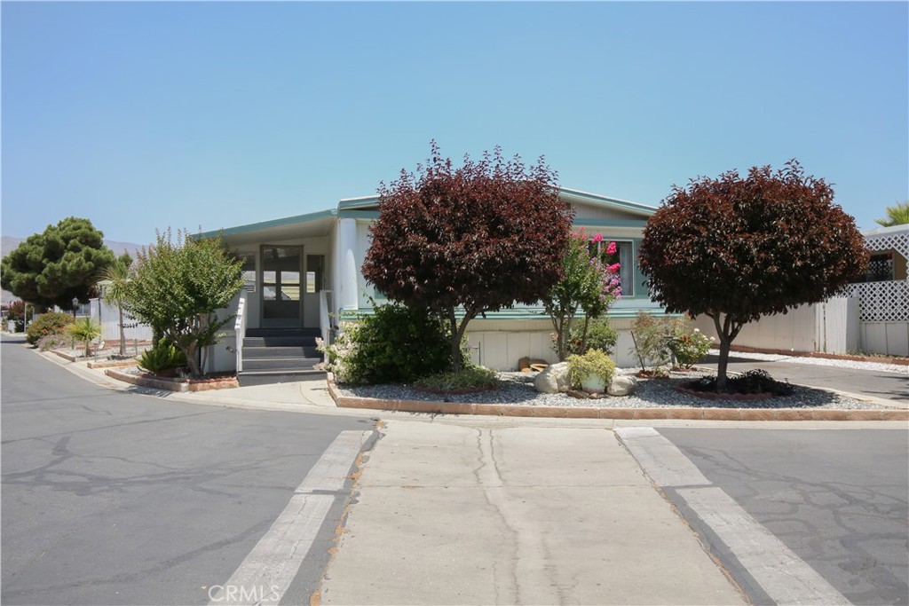 Searching for your next spot in San Jacinto in a 55+ Community? Look no further as this property might just be the one you are looking for! It comes with covered parking that can perfectly sit 2 vehicles and a quaint front garden that adds appeal to this corner-lot home. Unlike most manufactured homes, this abode has plenty of room to relax and entertain! The front side is a nice sun room where you can hang out with your family and friends, or simply read your favorite book while sipping your morning tea. Inside, there is a good-sized living room where you can also see a view of the kitchen (talk about not missing out on any action!). The kitchen comes with plenty of storage cabinets and is equipped with the necessary appliances for your convenience. Apart from the central AC, there are ceiling fans peppered throughout to keep you cool and comfy especially during summer. All of the bedrooms are well-maintained and come with capacious closets, giving you enough room for family or guests. There is a dedicated laundry area, too, making washing and drying a breeze. Situated near major roads and having access to fantastic amenities such as the pool, dog parks, and recreation areas, this home is not to miss!