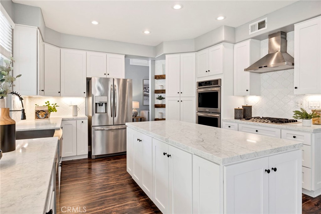 Discover this beautifully updated 5-bedroom, 3-bath pool home in the desirable Redhawk neighborhood of Rancho Palomar. This home is where Temecula lifestyle meets luxury and value being one of the lowest HOA and tax rate neighborhoods in Redhawk. Pride of ownership abounds in this open-concept living residence, offering owned solar, modern upgrades, high ceilings, and abundant natural light throughout. Step into a remodeled kitchen that will impress even the most discerning buyers with white shaker soft close cabinetry, quartz countertops, a modern range hood, gorgeous designer backsplash, floating shelves, stainless steel appliances and a large island open to the family room with a built in microwave, ideal for entertaining and everyday living. The home showcases LVP flooring, plantation shutters, neutral paint, brand new carpet in the bedrooms, and a bright, airy feel. Upstairs through a grand double door entry you will find a spacious primary suite which boasts vaulted ceilings, natural light, dual closets, and a 5 piece en-suite with a walk-in shower, double sinks, and a separate makeup vanity. The remaining three bedrooms with brand new carpet are just down the hall as well as a shared bath with a double sink vanity, plus a flex/loft room that can easily serve as a 6th bedroom, home gym, playroom, or theater for movie nights at home. Back downstairs you will find another full bedroom and full bath, perfect for multi-generational living, guests, or a home office. Enjoy parking your cars in an epoxy-finished 3 car garage with an EV charger, modern workspace, and storage. The large and spacious backyard offers room to relax or entertain with a heated pool that was resurfaced and retiled 1 year ago with a StoneScapes Pebble lifetime warranty, spa, new pool equipment, Crepe Myrtle trees, and a lush green lawn perfect for mini soccer games, backyard BBQ entertaining, or even a volleyball court. The manicured front yard exudes curb appeal, with low upkeep! Located minutes from the I-15 freeway in the desirable South Temecula area, this home offers an easy commute to San Diego or Orange County, making it perfect for buyers seeking more space, top-rated schools, and a high-quality lifestyle with nearby amenities. Zoned for the acclaimed Great Oak High School, and close to shopping, dining, Temecula Creek Inn, the Redhawk Golf Course, Pechanga, Old Town, and Temecula’s famous wineries, this home is well appointed and ready for holiday entertaining!