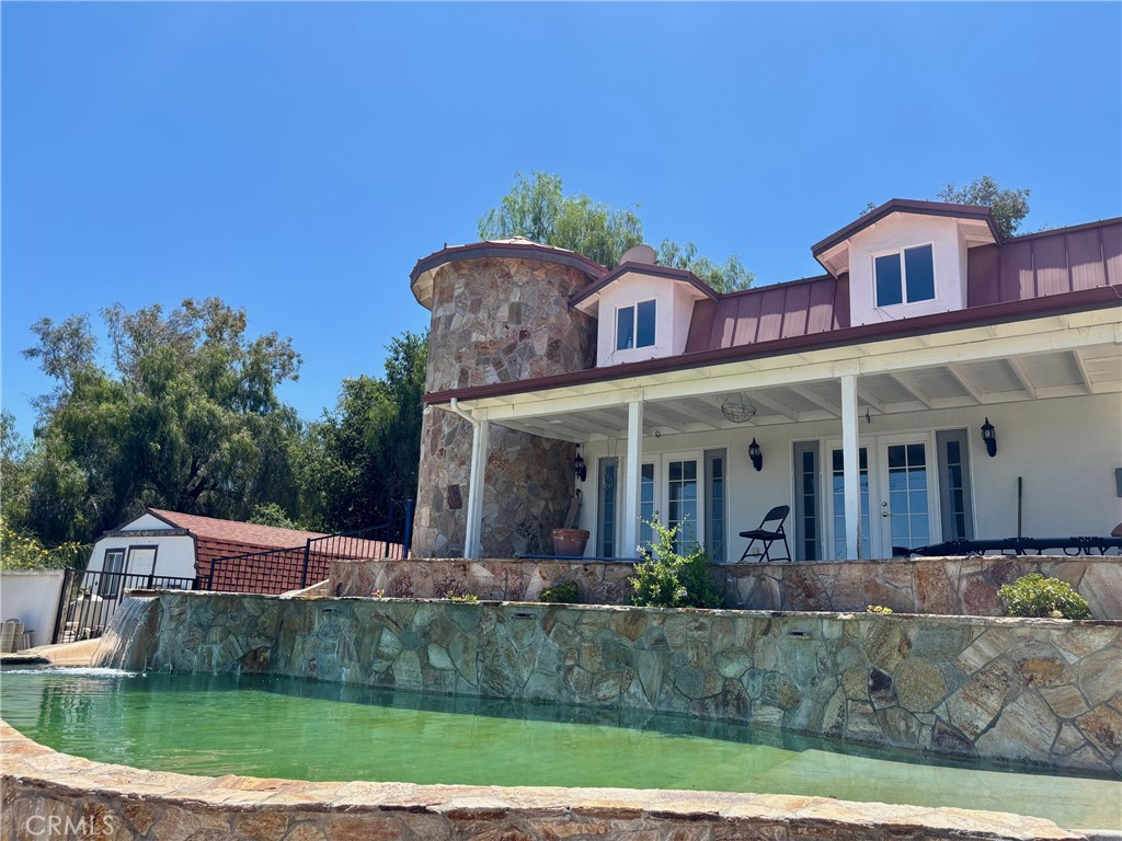 Welcome to your dream country retreat with two houses for multi-generation families! Nestled in the scenic hills of East Hemet. The remodeled property offers the perfect blend of peaceful rural living with convenient access to town amenities. Set on an expansive 9.93 acres ranch horse property, this property features endless breathtaking panoramic views, wide open space, and endless possibilities for those seeking privacy, hobby farming, or equestrian use. It has a main home and a guesthouse. Gated lot offers a lot of potential such as RV parking.
This 3,093 sf charming one-story main home offers 4 bedrooms, 2 full baths, and 1 3/4 bathrooms, a spacious formal living area filled with natural light, and well-appoted kitchen ideal for both everyday living and entertaining. The house comes with granite kitchen, wood burning stove, viking appliances, upgraded flooring, huge walk-in closet with upgrades, french door to private huge entertainment patio, front porch, and Indoor laundry. Step outside to enjoy the open land, mature trees, kitchen house, gazebo, and fresh country air — whether you're planning to garden, build a workshop, or bring your animals, the space is here. Detached 4-car garage. Lower portion of the property has a corral, huge barn on concrete pad as a potential workshop or storage, and a room to ride or train your hourses. Lots of spaces with stalls and cross fenced paddocks. The well produces about 15 gallons an hour and two large storage tanks. Conventional septic tank.
The 1,340sf 2-story guest house/casita has kitchen, living room, inside laundry, 3/4 bath downstairs, upstairs bedroom, a half bath, and power room, french door to stamped concrete patio, pool, waterslide, spa, and island BBQ area. Tile flooring, granite countertops, custom cabinets, central HVAC, ceiling fans, and also a handicap chair lift to the upstairs. This is very suitable for guest or grandmother quarters.
Located just a short drive from Temecula wine country, Diamond Valley Lake for fishing, Diamond Valley for Golf, and shopping and dining in Hemet, this property offers the tranquility of the countryside without sacrificing convenience. It's rare to find this much usable land in such a desirable area — don't miss the opportunity to make it your own.
SQFT not taped, Buyer’s responsibility to verify SQFT, schools, permits, and any other property related due diligence items. Sellers and Listing Agent do not warrant any info. Property to be sold AS IS.
