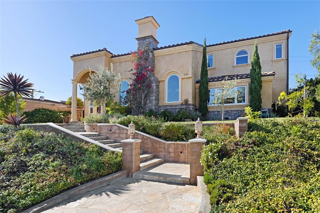 Located in the highly sought-after community of Newport Heights, this stunning Mediterranean-inspired home exudes elegance and sophistication. With approximately 4,200 square feet of living space, the expansive interior includes five bedrooms, five bathrooms, a private office, and a sprawling 340 square foot bonus room. The gourmet kitchen is a chef's dream, boasting top-of-the-line Thermador appliances, granite countertops, and custom cabinetry. The large island opens to the family room, complete with a fireplace and seamless access to a sun-filled, spacious courtyard. The living room boasts soaring two-story ceilings, an abundance of natural light, and a beautiful fireplace. A dramatic staircase leads to the second floor, which includes the primary suite, a spacious office, two bedrooms, three baths, and a bonus room. The primary suite features an impressive ensuite bath with a large walk-in shower, a spa tub, as well as dual walk-in closets and a private deck. Downstairs, also offers a guest suite with a walk-in closet, well appointed bath, and an additional bedroom. This home's exceptional features include distressed hardwood flooring, high ceilings, custom crown molding and baseboards, stone-clad bathrooms, casement windows, recessed lighting, and dual air conditioning units, as well as a two-car garage. Enjoy this opportunity to live in luxury as well as nearby fabulous restaurants, award-winning schools, and amazing beaches.