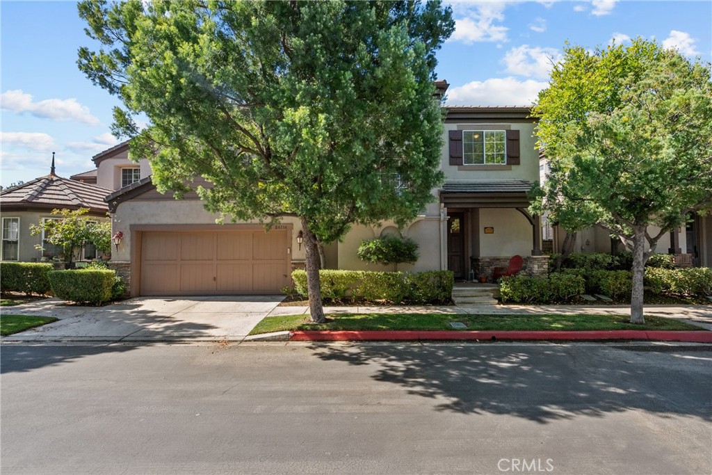Located on a picturesque tree-lined street in the sought-after Avignon community of Valencia, this charming French-inspired gated neighborhood is one of Santa Clarita’s best-kept secrets. Step onto the inviting front porch before entering this spacious 3-bedroom, 2.5-bath townhouse with over 1,900 sq. ft. of living space and direct-access 2-car garage. The home has been beautifully updated with new deluxe laminate wood-style flooring, new plush carpet, vaulted ceilings, recessed lighting, upgraded fixtures, and ceiling fans in all bedrooms. Cozy up by one of the two fireplaces with custom stonework, or enjoy the convenience of an indoor laundry room. The chef’s kitchen is equipped with quartz countertops, stainless steel appliances, upgraded plumbing fixtures, and abundant cabinetry. The backyard is a private retreat featuring new synthetic grass, rose bushes, and professionally designed landscaping. Upstairs, you’ll find a rare oversized secondary bedroom with a full en-suite bath with quartz countertops—essentially a second primary suite. The luxurious primary suite boasts two-tone paint, a two-sided fireplace, window seat, automated blinds, and dual walk-in closets. The spa-inspired bathroom offers a large soaking tub with fireplace and TV, dual vanities, and a separate shower. The Avignon community provides resort-style amenities including a pool, spa, charming courtyards, and plenty of guest parking. Conveniently located near award-winning schools, fine dining, shopping, golf, entertainment, and with easy freeway access, this property truly has it all. Offered at $799,999 this is A Must See!