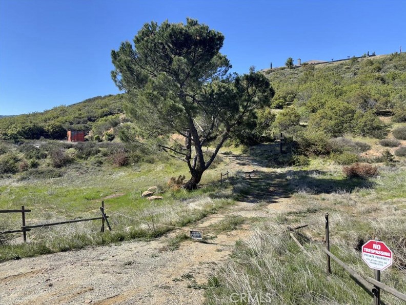 Discover 2.67 acres of country-style living, offering open land and scenic surroundings just off Old Highway 243. This property features easy access, an established driveway, and a flat area ready for future building with water source available — it simply needs to be turned back on! A storage container is also included for added convenience. Surrounded by natural landscapes and mature trees, the property offers a peaceful, private setting near neighboring parcels, providing both privacy and a sense of community. Bring your vision and explore the many possibilities this versatile property offers.