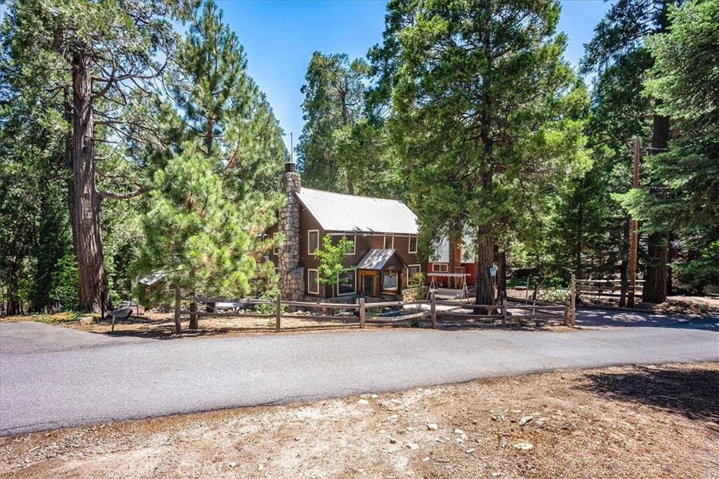 Incredible views from this gorgeous Mountain home. Pull in with ease into the 3-car, red brick driveway surrounded by pines and lush, mature trees, and take in the fantastic views of nature. Entertaining areas with large Decks on the front, sides, and back of the home. 3 bedrooms, two of which are upstairs. The bottom-floor bedroom can be used as a library, den, or office, and features a separate entrance that leads to the outside deck. There is one bathroom located on the main floor, and another is upstairs. The main floor living area boasts open-concept living at its finest. Nestle up on those beautiful, crisp snow days to a large, wood-burning fireplace in the living room. There are also numerous windows throughout the home bringing in natural sunlight. The downstairs laundry area features a sink, a refrigerator storage area, and an exterior entrance. There is yet another large deck on the second floor, off the loft area, with fantastic views. A nicely sized shed sits in the backyard, surrounded by areas for gardening. Whether you are looking for the quiet, peaceful lifestyle of living in a mountain setting or craving adventure, Twin Peaks has it all. Plus, Wildlife galore, including Birds, Deer, and Bears. Close to Lake Arrowhead, Lake Gregory, and Skypark at Santa's Village.