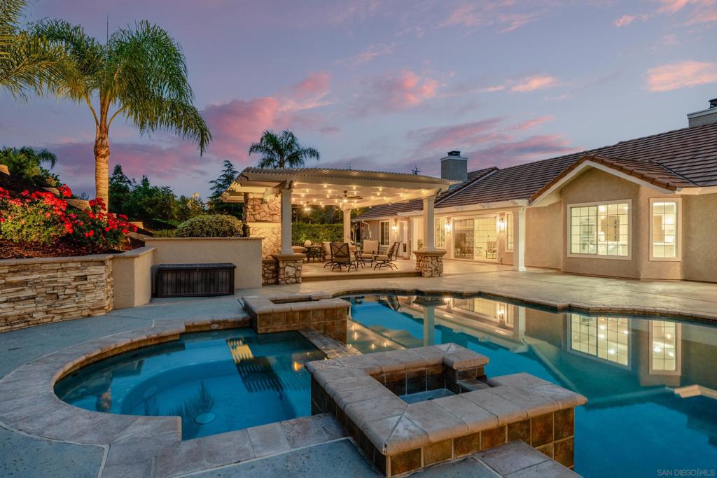 Nestled in the heart of town, this gated 3.75-acre property offers the rare feeling of your own private slice of countryside—without sacrificing convenience or access to city amenities. Beautifully remodeled, the 3,800 sq. ft. main residence blends luxury, comfort, and self-sustaining living with 4 spacious bedrooms, an office, and formal living and dining rooms—perfect for both elegant entertaining and everyday ease. At the heart of the home is a show-stopping chef’s kitchen with new Thermador appliances and an oversized custom island offering generous prep and seating space. Step outside into your own private resort with a heated pool and spa, covered outdoor living room with fireplace, and expansive grounds ideal for year-round entertaining. The detached 800± sq. ft. pool/guest house features a full bathroom and Sub-Zero 200-bottle wine fridge—perfect for overnight guests, game nights, or a private studio. Designed for sustainability, the fully solar-powered estate includes agriculture-zoned water, a self-watering garden, fruit trees, and a producing mandarin grove (~375 trees yielding ~$3,500/year, with potential for $10,000+ at full maturity). The custom chicken coop has a real shingle roof, 16-gauge wire buried 3 ft. deep, plus power and water for year-round functionality. Bonus: Enjoy front-row views of Temecula’s 4th of July fireworks. Minutes from top schools, shopping, and wineries—this is luxury country living in the heart of Temecula.