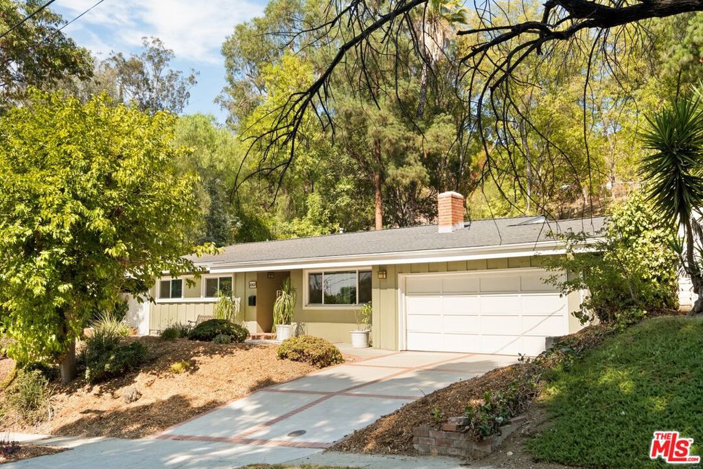 Blending vaulted ceilings, expansive windows, and a modernized open layout, 20607 Martha St offers three bedrooms and two baths across a thoughtfully reimagined single-level home, where light-filled interiors connect seamlessly to private outdoor spaces designed for entertaining and hillside privacy. The living room connects seamlessly to a flexible den and a dining area wrapped in glass, creating distinct yet fluid spaces for gathering. At the heart of the home, a modern kitchen features quartz countertops, custom cabinetry, designer tile backsplash, and a suite of stainless-steel appliances centered around a professional Thor gas range. The private primary suite is complete with a walk-in closet and en-suite bath, while secondary bedrooms provide comfort and flexibility for family, guests, or a home office. Designed for seamless indoor-outdoor living, the rear grounds are ideal for entertaining, with a large brick patio, built-in spa, and multiple seating and dining areas set against a backdrop of mature trees and hillside privacy. A two-car garage and generous driveway complete this well-appointed home, offering comfort, convenience, and timeless California style.