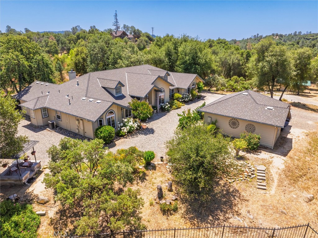 Your Dream Retreat Awaits! This private, creek-front property at the end of a peaceful cul-de-sac offers the perfect blend of luxury, sustainability, and outdoor living. Set on 3.75 usable acres, the 3,045 sq ft single-story home features vaulted ceilings with wood beams, dormer skylights, and an open-concept design filled with natural light. With 4 bedrooms, 3 bathrooms, and a dedicated office, there’s space for every need.
The kitchen boasts black stainless appliances, a large island, and generous storage, while the cozy wood-burning stove adds warmth and charm. Designed for efficient living with dual HVAC systems, 39 owned solar panels, private well, a water storage tank, oversized septic (great for a future ADU), whole-house water filtration, and owned propane tank.
Enjoy a Pebble Tec pool with waterfall, pond views, 8 fruit trees, mature landscaping, and historic Indian grinding holes near the seasonal creek. Outside you'll find a gated entrance, basketball hoop, detached garage, covered dog kennel and chicken yard, additional animal pens, sheds, and a 20-ft sea container for storage. Just minutes from Hwy 41 for the commuters, and a short drive to Bass Lake and Yosemite for more outdoor fun! A rare opportunity to own a one-of-a-kind mountain sanctuary - Schedule a showing today!