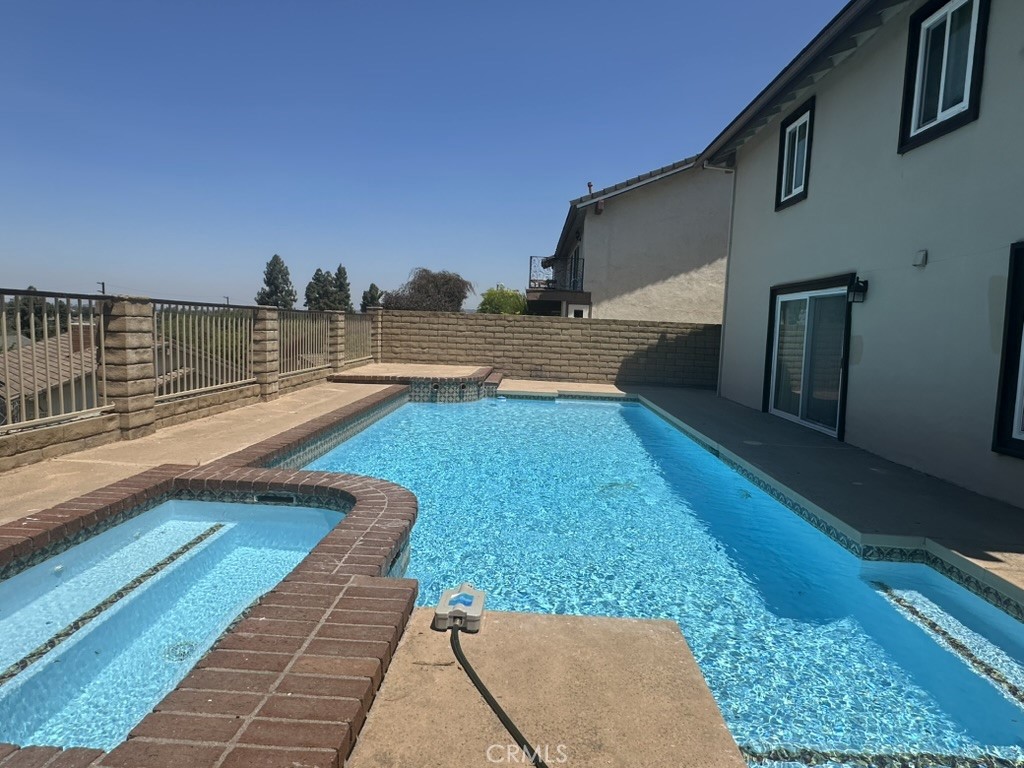 Nestled in the gated community of Winnwood Estates, this 4-bedroom, 3-bathroom pool home offers 3,563 square feet of living space. Located at the end of a quiet cul-de-sac, the property features scenic city views. The spacious layout includes a formal living room and a large family room, ideal for entertaining. The kitchen offers recessed lighting, generous counter space, and ample cabinetry, with an adjacent dining area suited for both everyday use and gatherings.
The primary suite includes an en-suite bathroom with dual vanities, a soaking tub, and a walk-in closet. Three additional bedrooms offer flexibility for various needs. A separate 2-bedroom guest unit with its own kitchen and family room is located below the three-car garage.
Outdoor highlights include a swimming pool, jacuzzi, and balconies with sweeping views. Conveniently located near freeways, shopping centers, and restaurants.