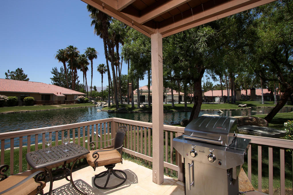 South-facing end unit condo located in the Palm Lake guard-gated community-just across from Palm Desert High School. This beautifully updated lakefront condo offers lake, fountain, and mountain views. Enjoy peace and privacy away from noisy streets while soaking in the tranquil sounds of the water just outside your window. Featuring window upgrades (2021), updated blinds, Bradford White water heater, refrigerator, and Bosh dishwasher. Natural stone tile bathrooms, granite countertops throughout, repainted, and updated lighting, switches and outlets, this home is move-in ready. The kitchen ceiling has been raised, adding to the open, airy feel. The enlarged guest bedroom fits a king-size bed, perfect for guests or added comfort. Other highlights include a fireplace and some premium furnishings (negotiable outside of escrow). Features an assigned carport and an open parking space. Exceptionally maintained with a strong 10+ year vacation rental history. Located in a resort-style community with 2 pools/spas, tennis & volleyball courts, sauna, gym, and clubhouse, just minutes from El Paseo, restaurants, and shops. A truly unique living space!