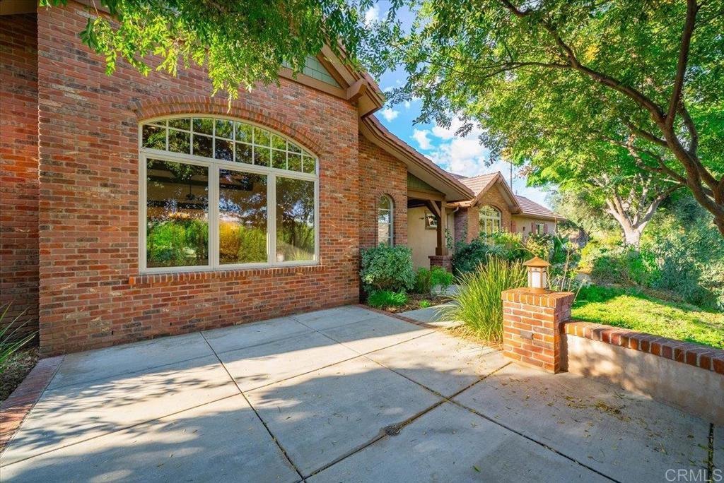 Surround yourself with timeless luxury in this custom Craftsman-style estate, masterfully designed by architect Carole Wylie and built in 2009 by the acclaimed general contractor Woodcrest Homes, Inc. Set on over six acres in a serene, park-like setting near the end of a private road, the property captures panoramic valley views from nearly every room. Exceptional craftsmanship is evident throughout, featuring 2x6 construction, travertine flooring, a massive brick fireplace, and a 16-foot open-beam ceiling with hand-hewn solid wood beams. The oversized chef’s kitchen offers a generous center island, custom cabinetry, granite countertops, and a built-in wine rack, perfect for entertaining. The luxurious primary suite, privately situated in its own wing, includes a spa-inspired bathroom with stone tile shower and soaking tub. Down the hall are two thoughtfully designed Jack-and-Jill bedrooms, providing ideal family or guest accommodations. Experience seamless indoor-outdoor living with three spacious patios, surrounded by mature landscaping and natural beauty. Outdoor amenities include a newly constructed greenhouse, large chicken coop, 14 irrigated raised garden beds, and a mature fruit tree orchard, perfect for a refined country lifestyle. The home also features both well and city water with a 10,000-gallon water storage tank, epoxied garage floors, a circular motor court driveway for ease of access, an installed whole-house Generac generator, 8-foot-high solid wood interior doors, and a concrete tile roof for lasting durability. This remarkable estate represents the perfect blend of architectural sophistication, natural tranquility, and enduring craftsmanship.