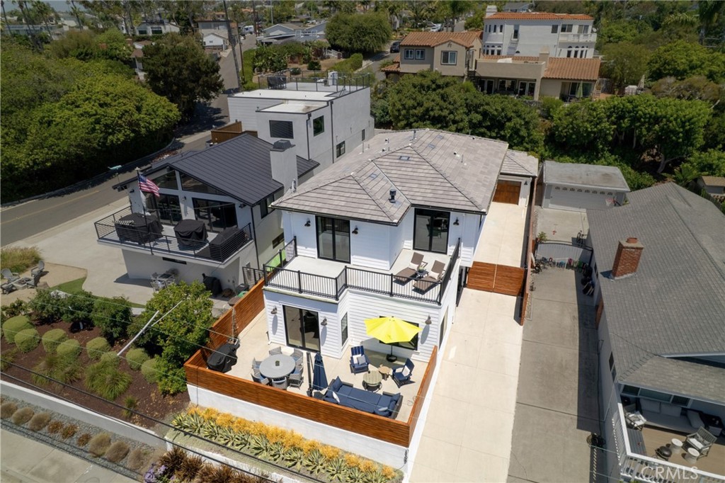 Welcome to 1703 S Ola Vista—a recently constructed coastal sanctuary in the heart of San Clemente, where elevated design meets effortless California living. Just moments from the sand, this five-bedroom, five-bathroom home blends modern elegance with a relaxed, beachside spirit. The home greets you with a bright, open floor plan, wide-plank Bellawood White Oak flooring, and thoughtfully curated designer finishes throughout. At the center of it all is a stunning gourmet kitchen, anchored by a dramatic Everest Quartz island with waterfall edges and bar seating. A full suite of premium appliances—including a 48” paneled Sub-Zero refrigerator, 6-burner Wolf cooktop, Sub-Zero microwave drawer, Bosch 800 Series dishwasher, and a 46-bottle dual-zone wine fridge—makes this kitchen as functional as it is beautiful. Custom cabinetry, designer tilework, and a farmhouse-style apron sink complete the space with style and intention. La Cantina accordion doors connect the main living areas to multiple outdoor decks, inviting in ocean breezes and creating the ultimate indoor-outdoor flow. The open-concept layout includes a spacious formal dining area with custom built-ins, and two main-level en-suite bedrooms—perfect for guests or multigenerational living. Upstairs, a bonus room provides the perfect secondary lounge, media room, or retreat. The primary suite is a private escape, featuring a cozy fireplace with reclaimed 19th-century barn beam mantle, private deck access, and a spa-inspired bath with dual vanities, walk-in closet, a freestanding soaking tub, and a large walk-in shower with oversized rain fixture and handheld wand. Additional highlights include a 10-year new construction warranty, eco-friendly hardscaping, an outdoor shower, and a detached two-car garage with epoxy flooring and EV charging. Located just a short stroll from world-class beaches, the San Clemente Beach Trail, and Avenida Del Mar’s shops and dining, 1703 S Ola Vista offers a rare opportunity to own a true coastal luxury residence.